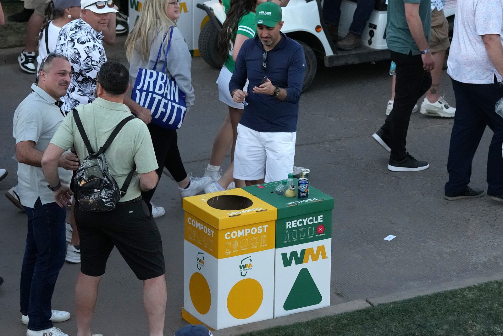 The gallery walks past some of the Waste Management bins at the 18th hole during the first round of the Waste Management Phoenix Open PGA Tour golf tournament at the TPC Scottsdale Thursday, Feb. 6, 2025, in Scottsdale, Ariz. (AP Photo/Ross D. Franklin)