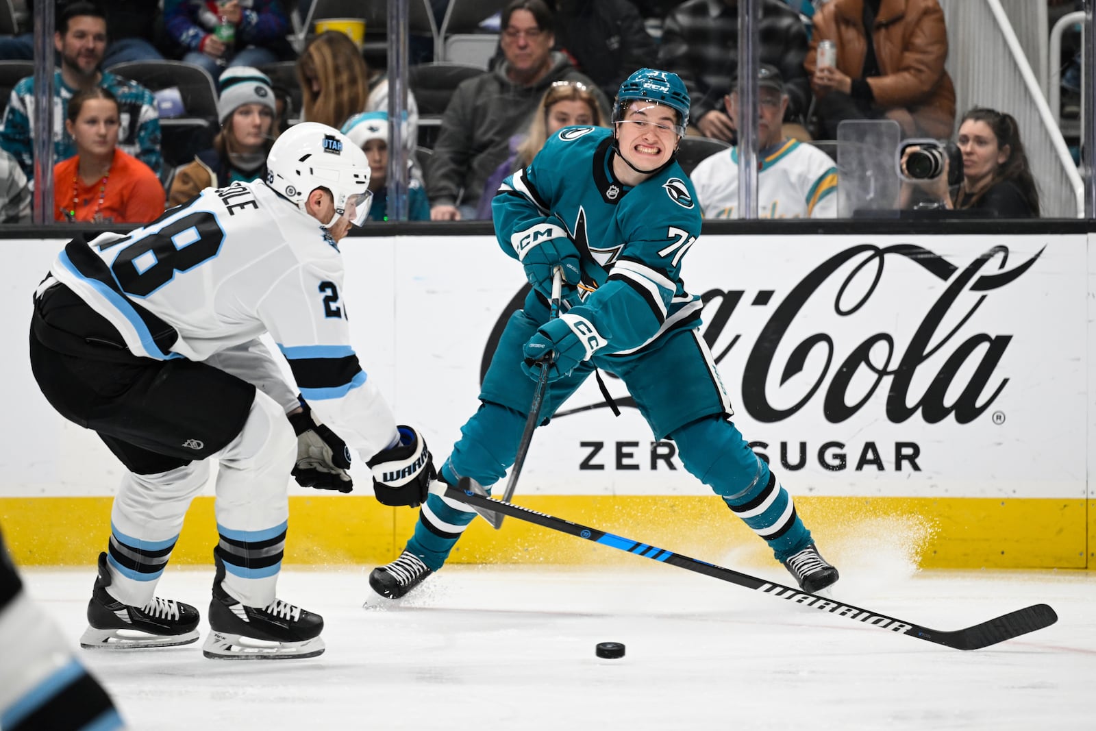 San Jose Sharks center Macklin Celebrini (71) crosses the puck against Utah Hockey Club defenseman Ian Cole (28) during the first period of an NHL hockey game Saturday, Dec. 14, 2024, in San Jose, Calif. (AP Photo/Eakin Howard)