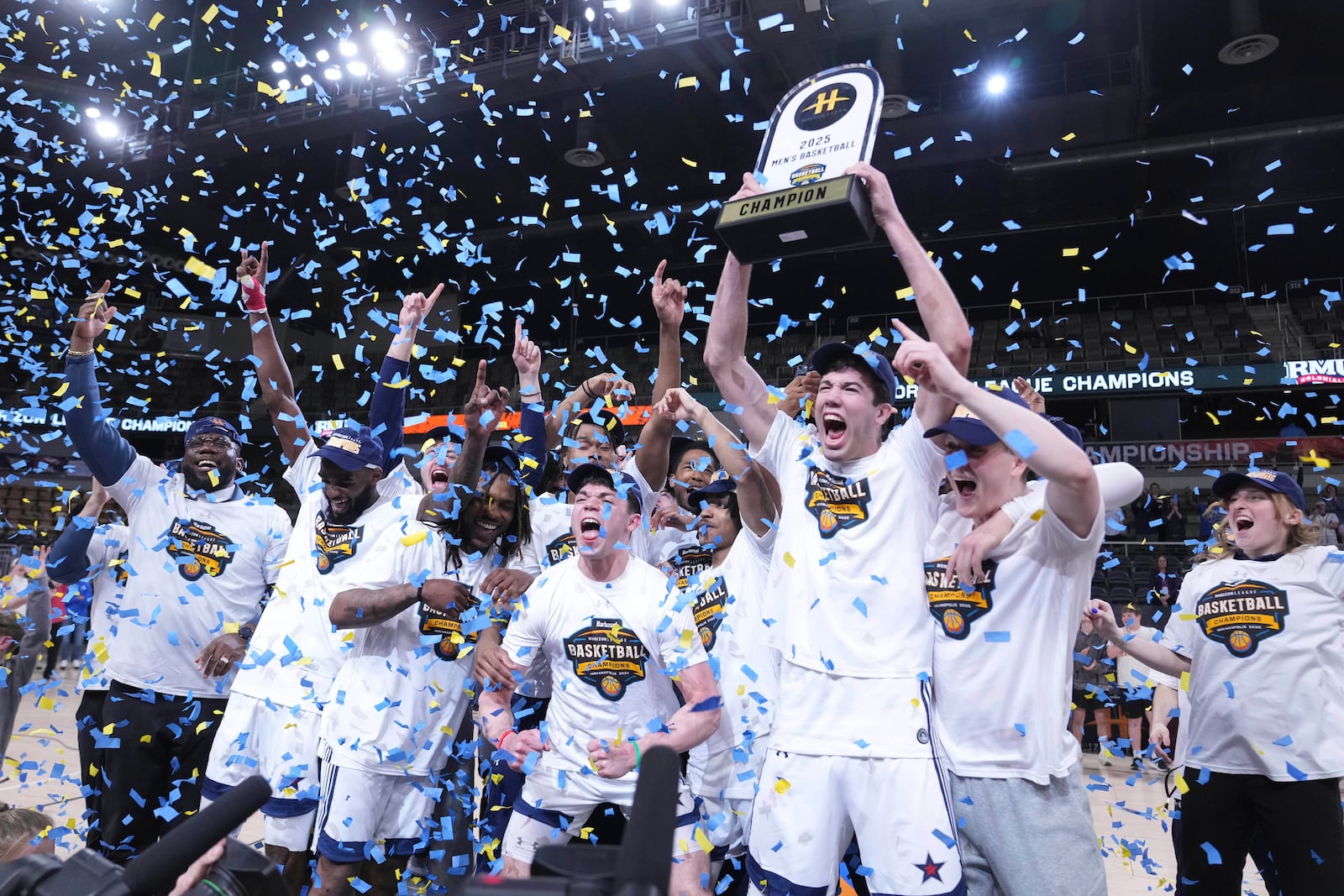 Robert Morris players celebrate with the trophy after defeating Youngstown State in an NCAA college basketball game in the championship of the Horizon League tournament in Indianapolis, Tuesday, March 11, 2025. (AP Photo/Michael Conroy)