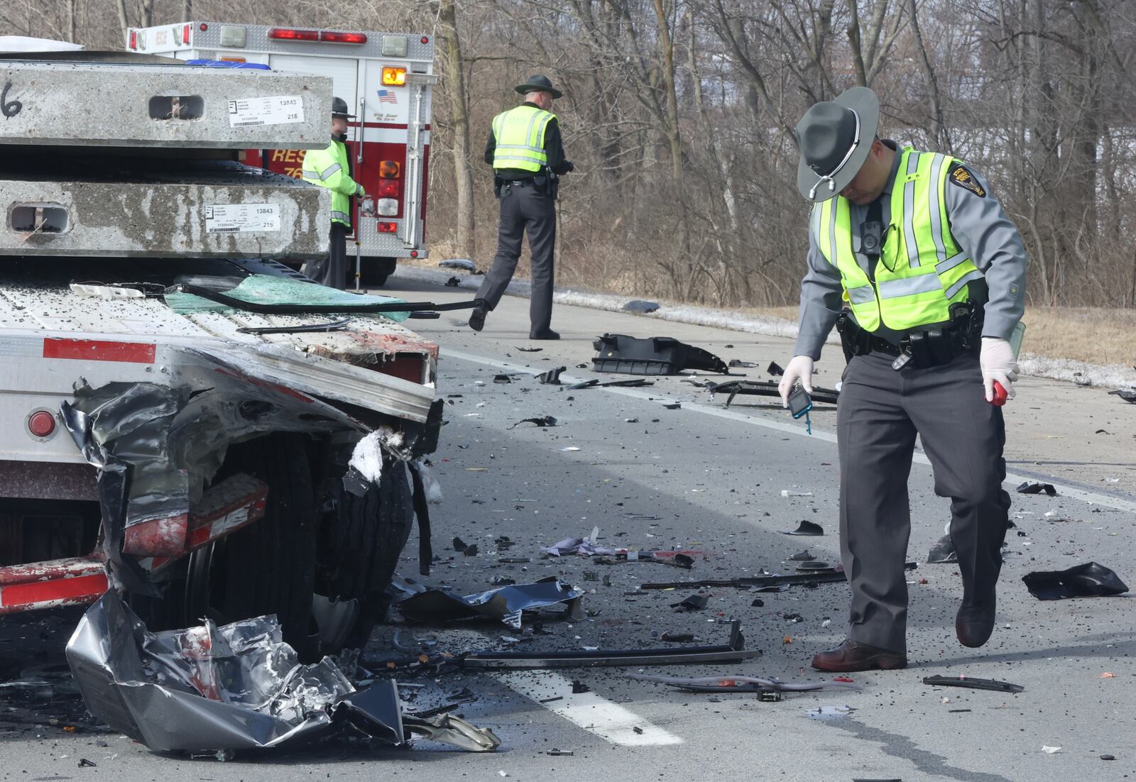 Troopers examine the wreckage after an SUV slammed into the back of a broken down flatbed semi trailer Thursday morning, Feb. 10, 2022, on Interstate 70 West in Harmony Twp., killing its driver. BILL LACKEY/STAFF