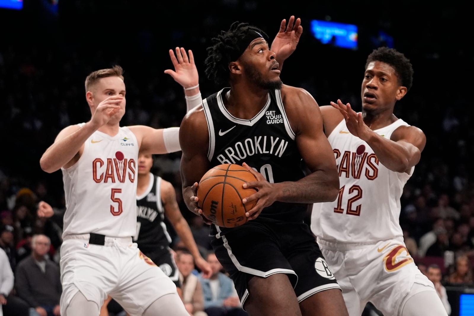 Cleveland Cavaliers' De'Andre Hunter (12) and Sam Merrill (5) defend Brooklyn Nets' Day'Ron Sharpe (20) during the second half of an NBA basketball game Thursday, Feb. 20, 2025, in New York. (AP Photo/Frank Franklin II)