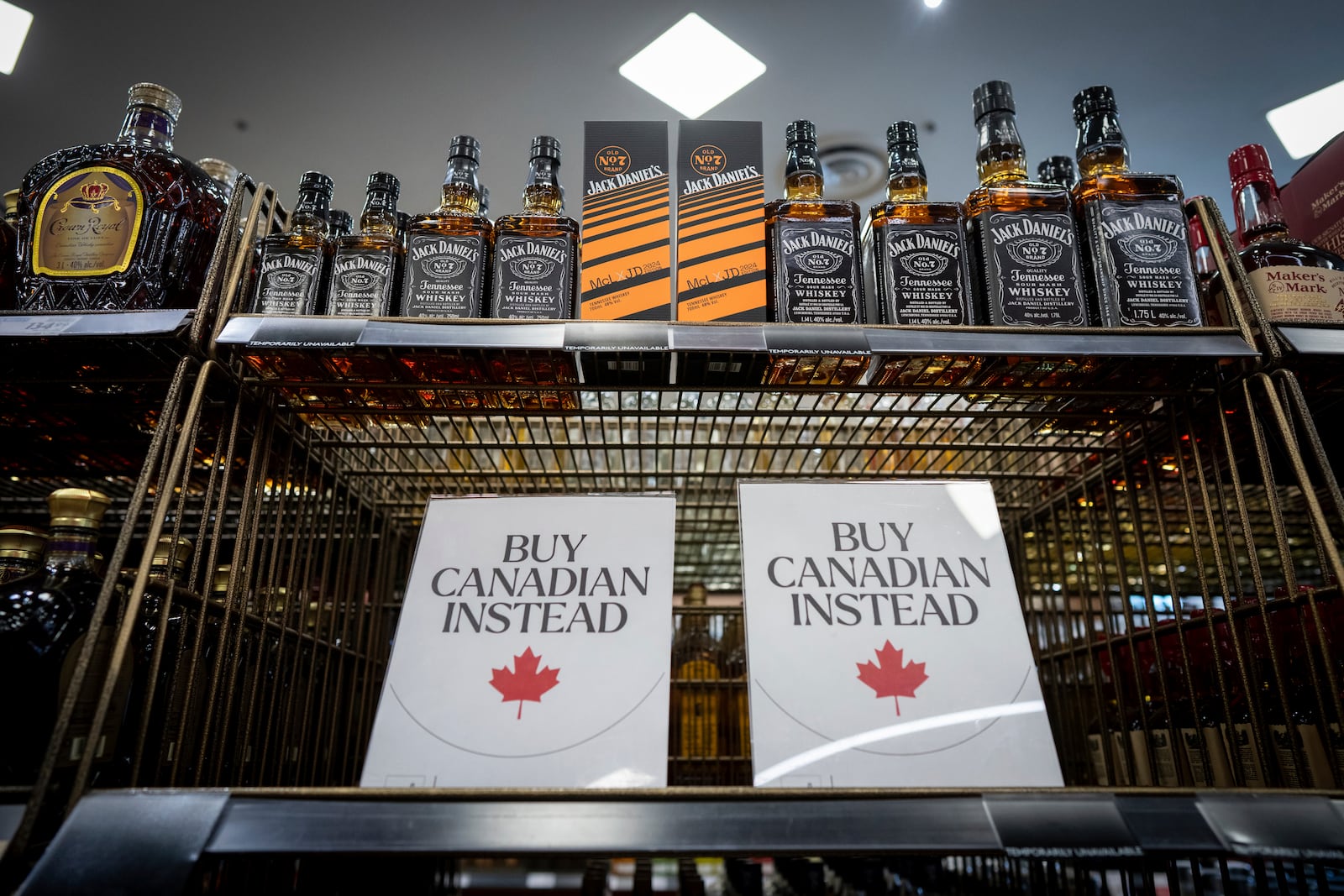 A sign is placed in front of the American whiskey section at a B.C. Liquor Store before top selling American made products are to be removed from shelves as a demonstration for media in Vancouver, B.C., Sunday, Feb. 2, 2025. (Ethan Cairns/The Canadian Press via AP)