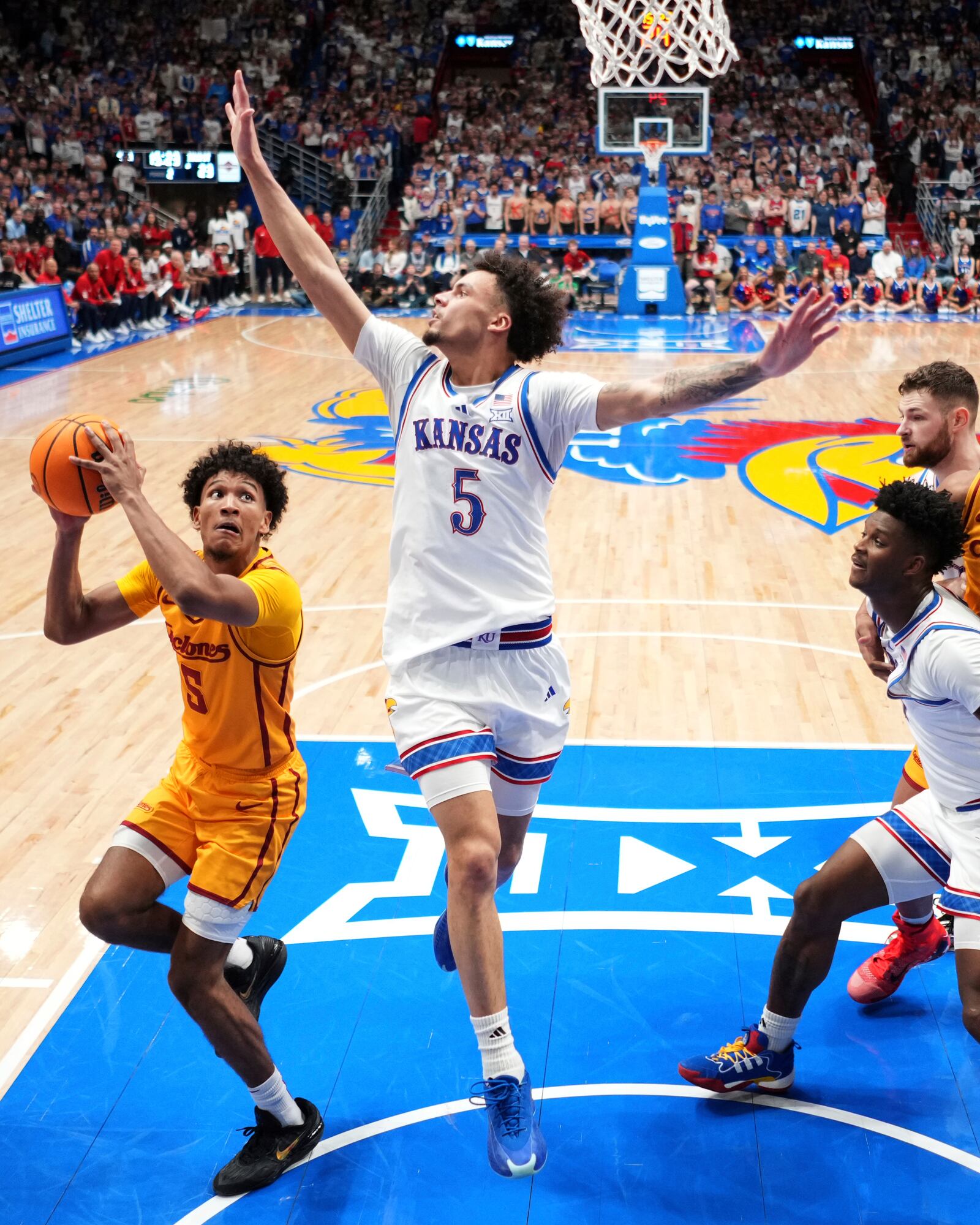 Iowa State guard Curtis Jones, left, looks to shoot under pressure from Kansas guard Zeke Mayo (5) during the second half of an NCAA college basketball game, Monday, Feb. 3, 2025, in Lawrence, Kan. (AP Photo/Charlie Riedel)