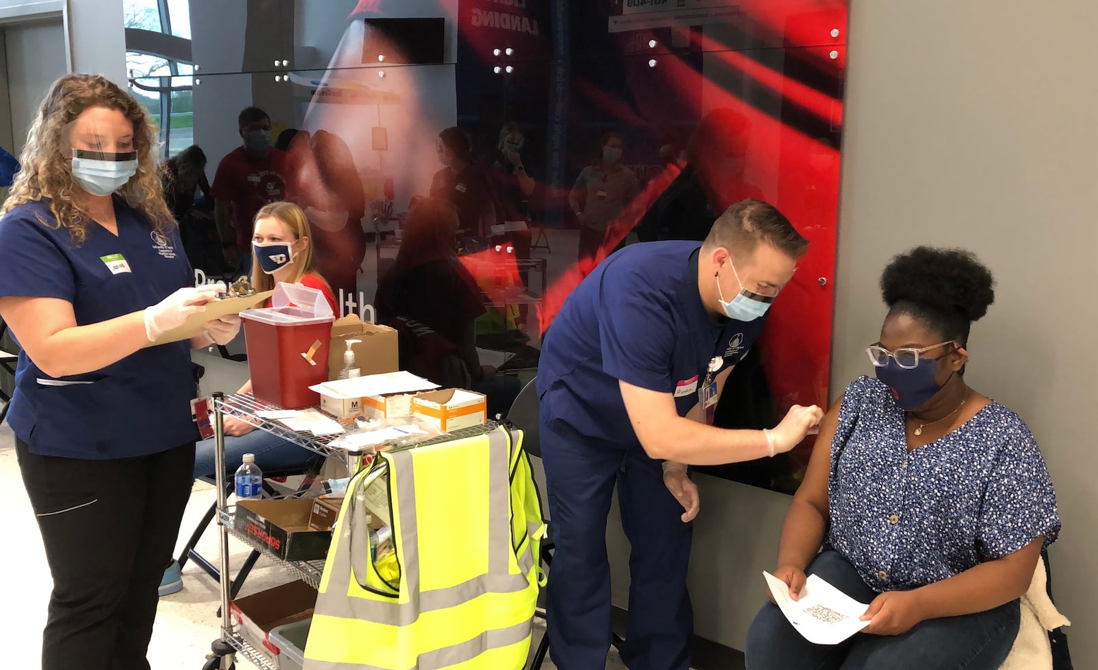 Premier Health medical staff prepare to give Alexandria Bennett, 22, her COVID-19 vaccine at the University of Dayton Arena on Sunday April 11, 2021. Bennett, of Pickerington, is a senior majoring in communication arts at UD. LYNN HULSEY/STAFF