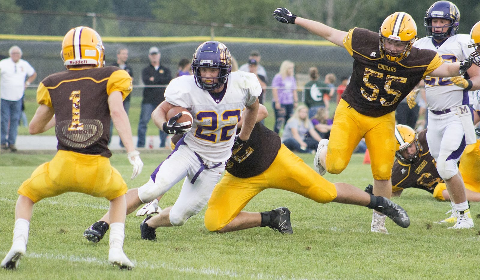 Mechanicsburg’s Joey Mascadri runs through a hole in the Kenton Ridge defense toward Andrew Good, 1, and away from Brandon Collins, 55, during Friday night s season opener at Kenton Ridge. Jeff Gilbert/CONTRIBUTED