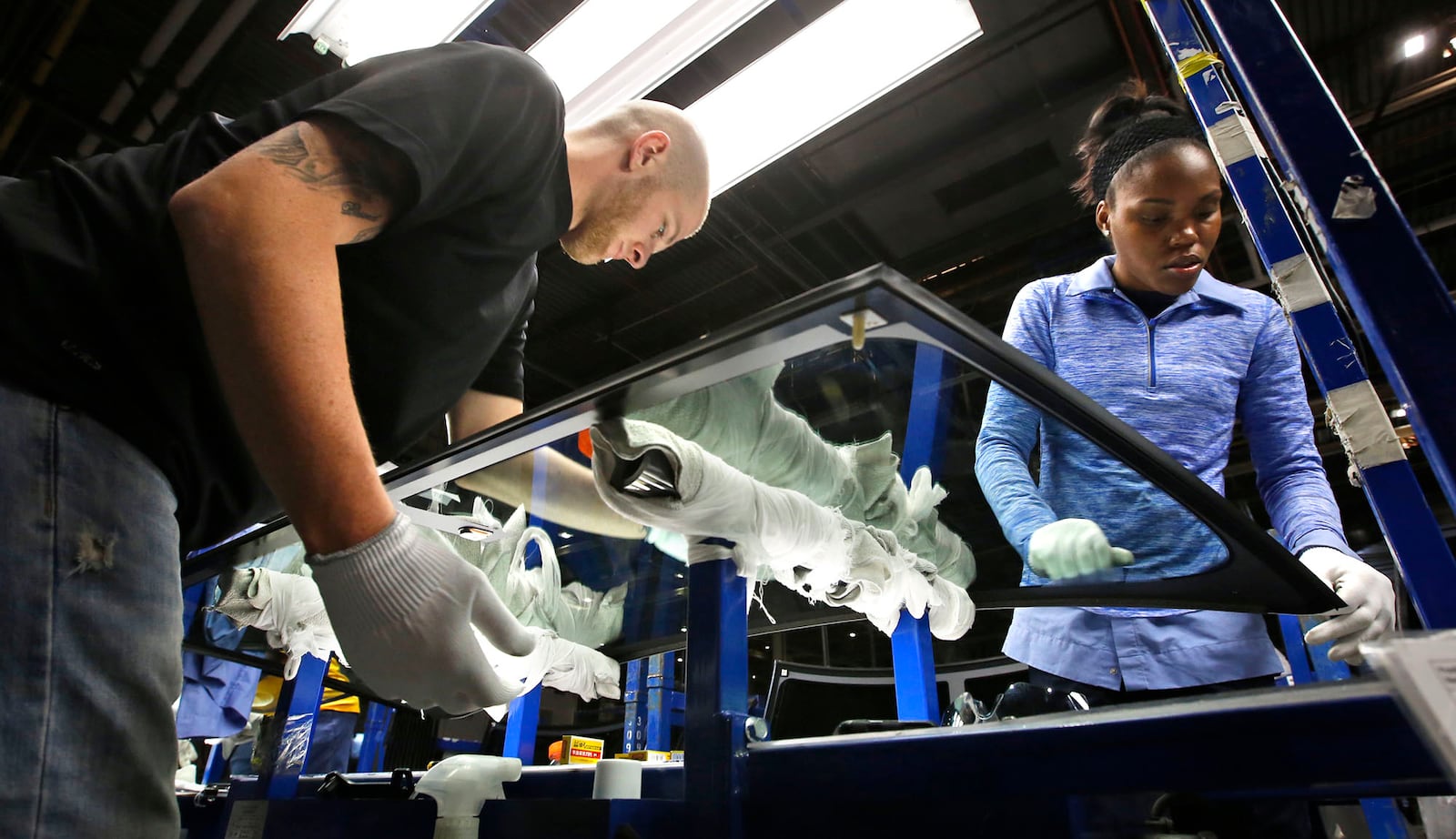 10-3-16 -- Fuyao Glass America has progressed at a pace that is years ahead of its original schedule and now employs more than 2,000 people. Dustin Sparkman, left, and Deraesha Stewart work as a team to clean and quality check windshields in the Moraine plant..  TY GREENLEES / STAFF