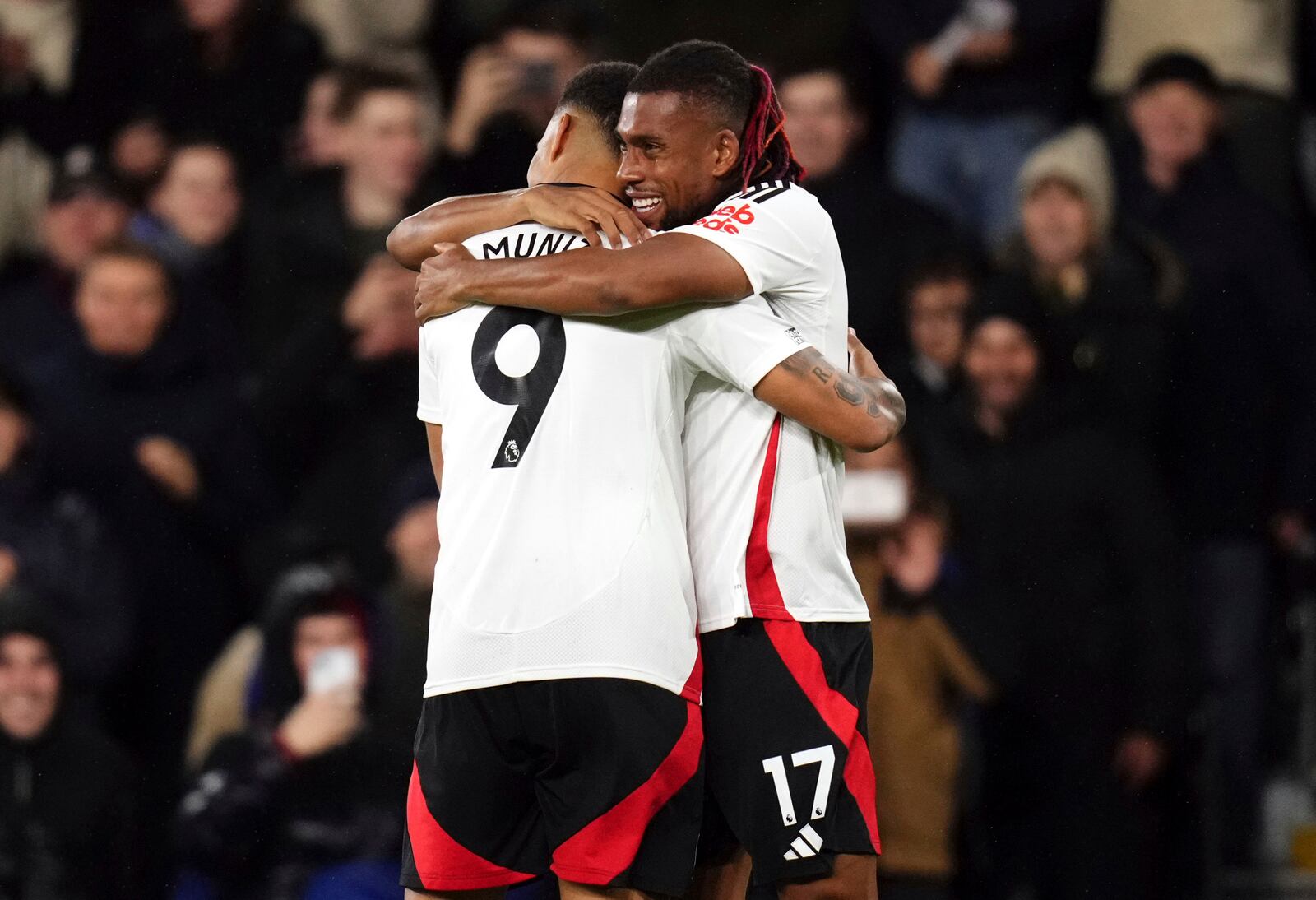 Fulham's Alex Iwobi, right, celebrates scoring the opening goal with Rodrigo Muniz during the Premier League match between Fulham and Brighton at Craven Cottage, London, Thursday Dec. 5, 2024. ( John Walton/PA via AP)