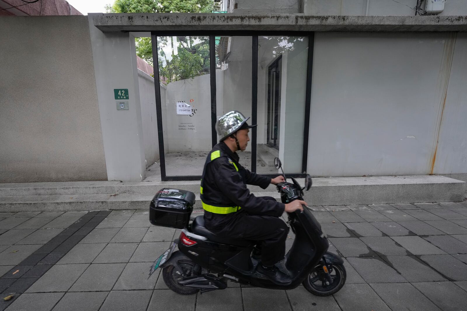 A man rides past the shuttered Text&Image bookstore in Shanghai, Oct. 9, 2024. (AP Photo/Andy Wong)