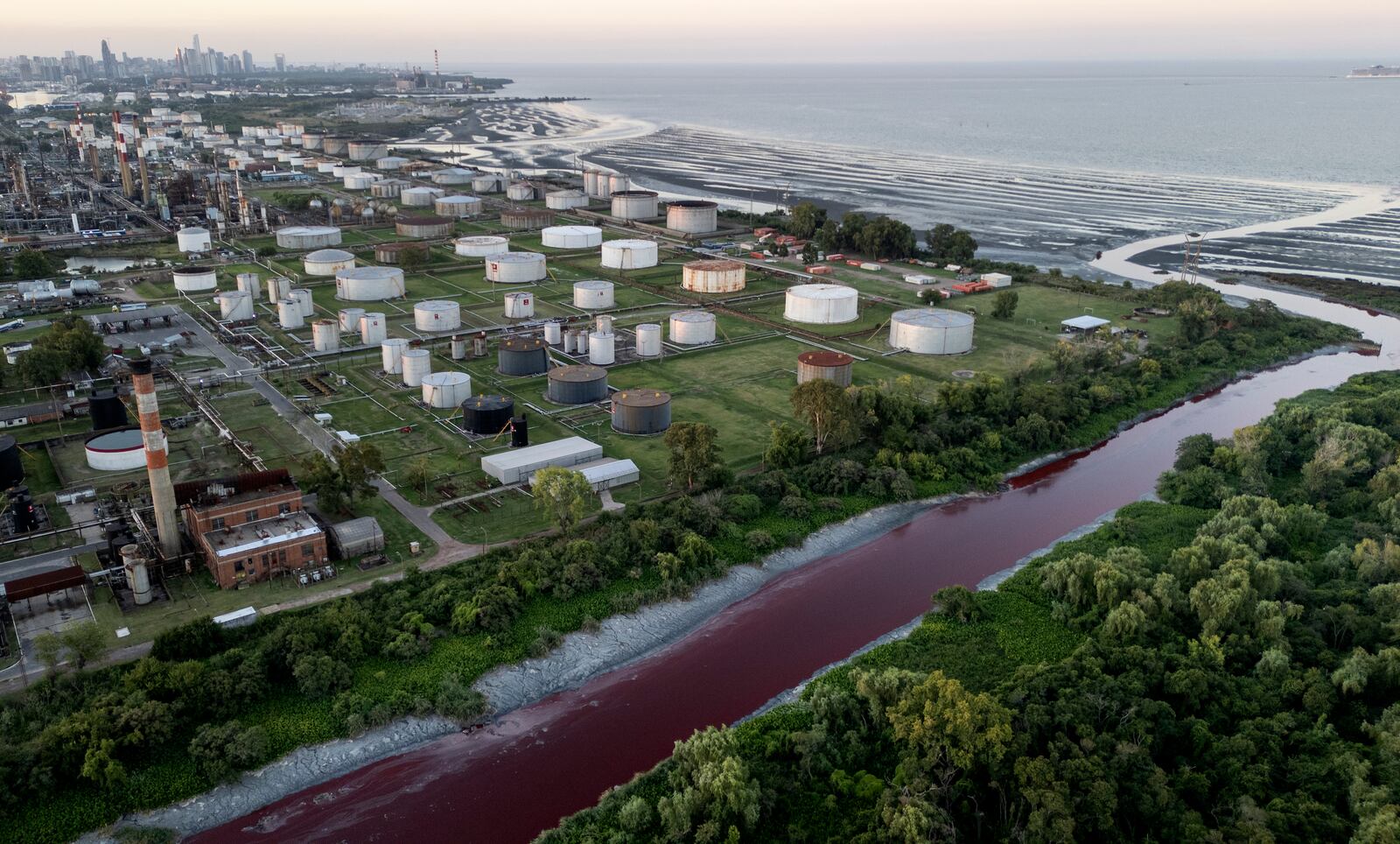 An aerial view of the "Sarandi" stream dyed red due to unknown contaminants allege residents, in an industrial neighborhood on the outskirts of Buenos Aires, Argentina, Thursday, Feb. 6, 2025. (AP Photo/Rodrigo Abd)