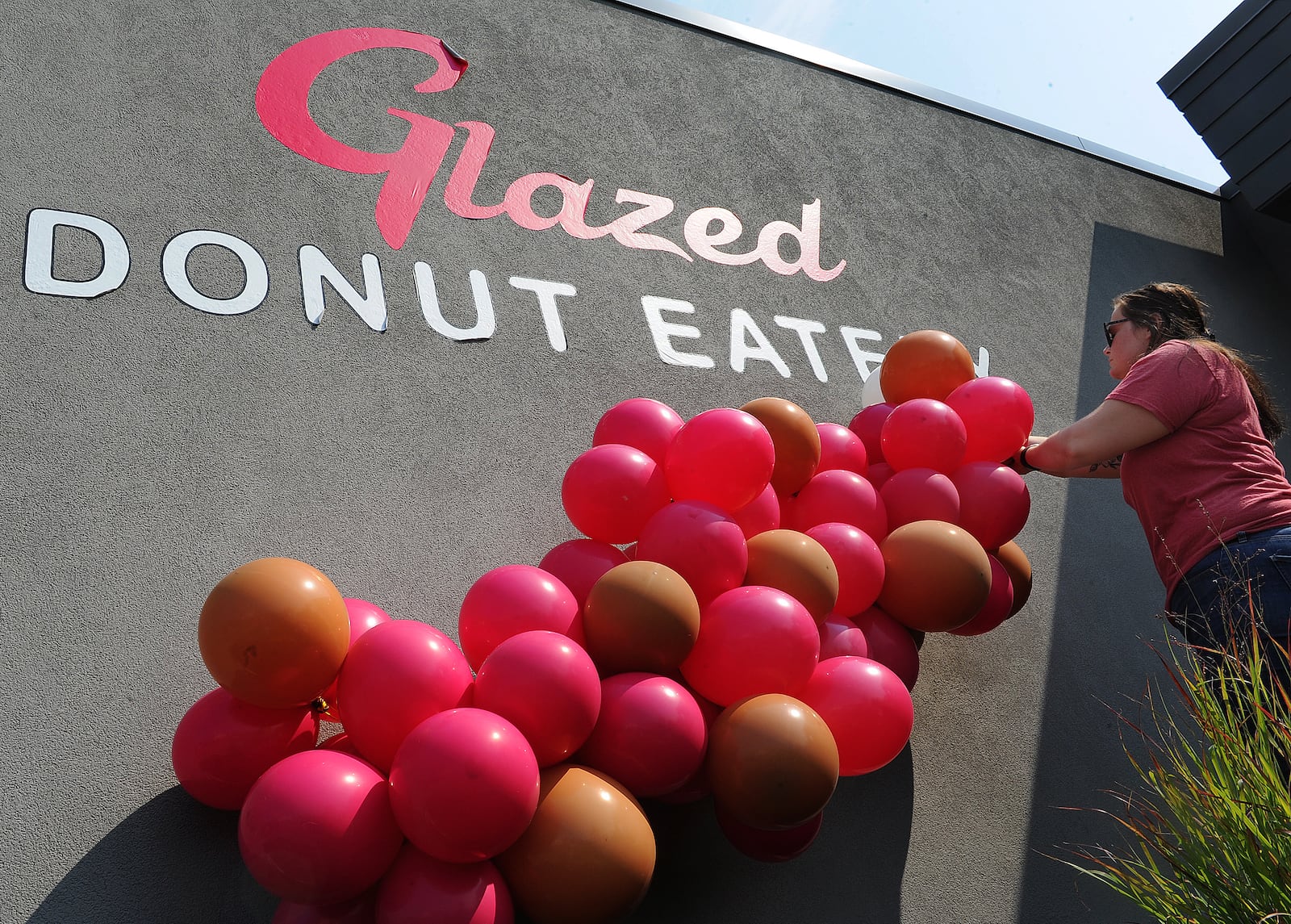 Blake Roysdon, owner of BNR Balloons, adds her touch of flare Friday, July 23, 2021 to the new Glazed Donut Eatery in Xenia. MARSHALL GORBY\STAFF