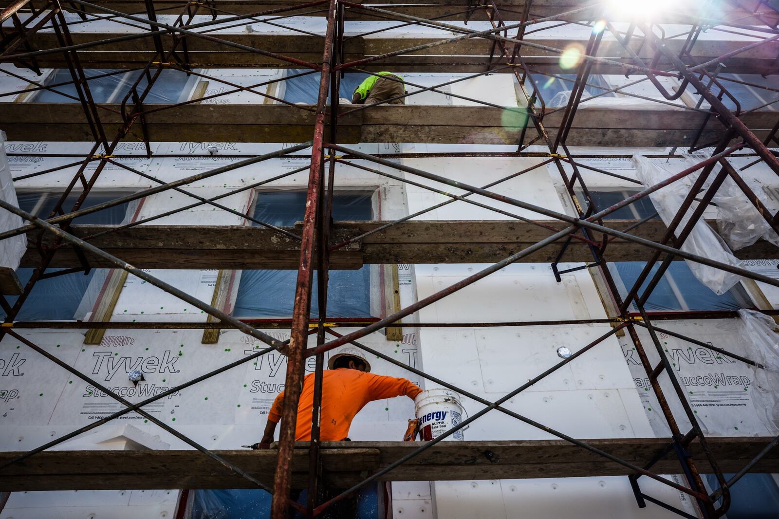 Construction workers applies insulation to the side of a large building on Brown St. Wednesday June 16, 2021. Jim Noelker/Staff