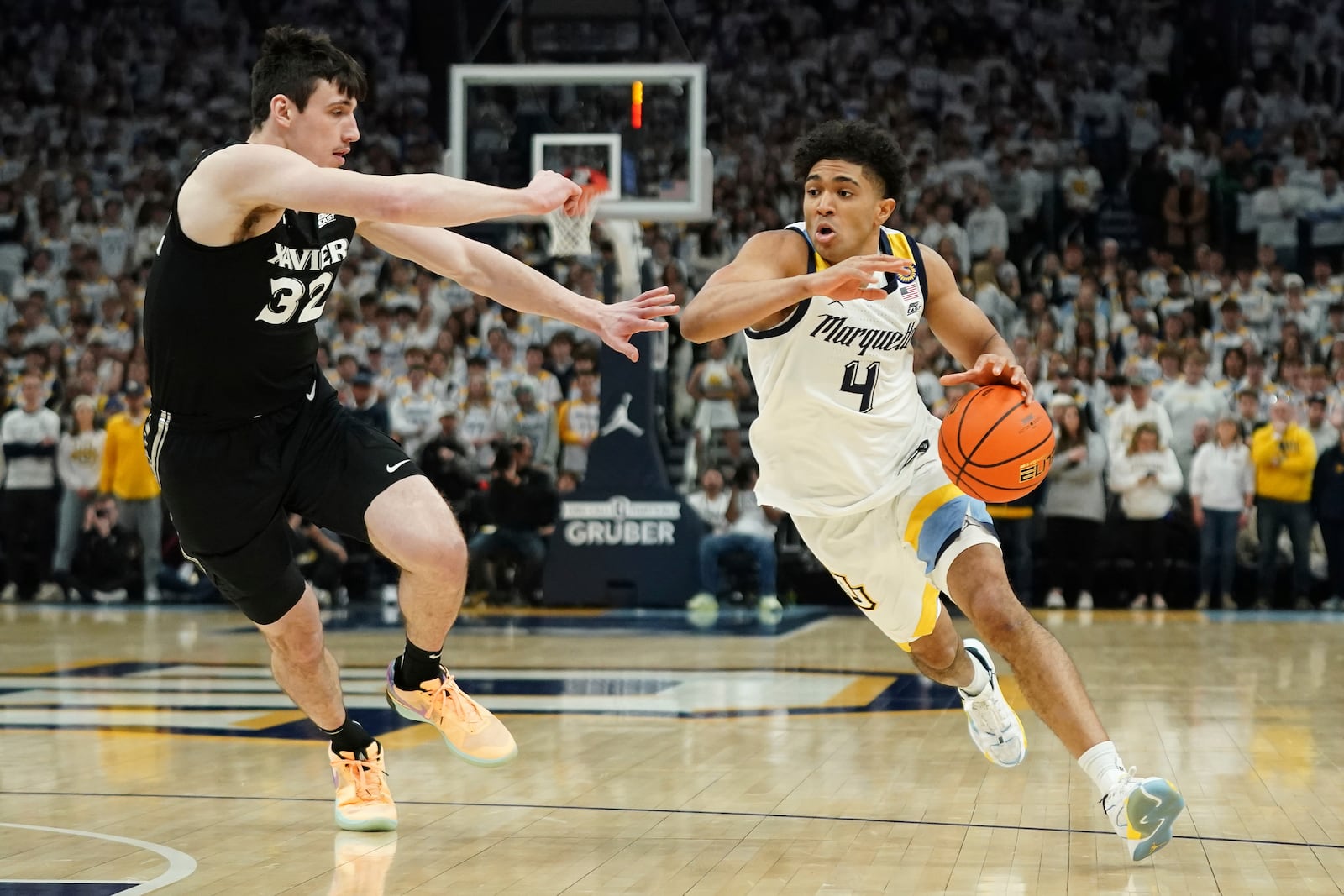 Marquette's Stevie Mitchell (4) drives to the basket against Xavier's Zach Freemantle (32) during the first half of an NCAA college basketball game Saturday, Jan. 18, 2025, in Milwaukee. (AP Photo/Aaron Gash)