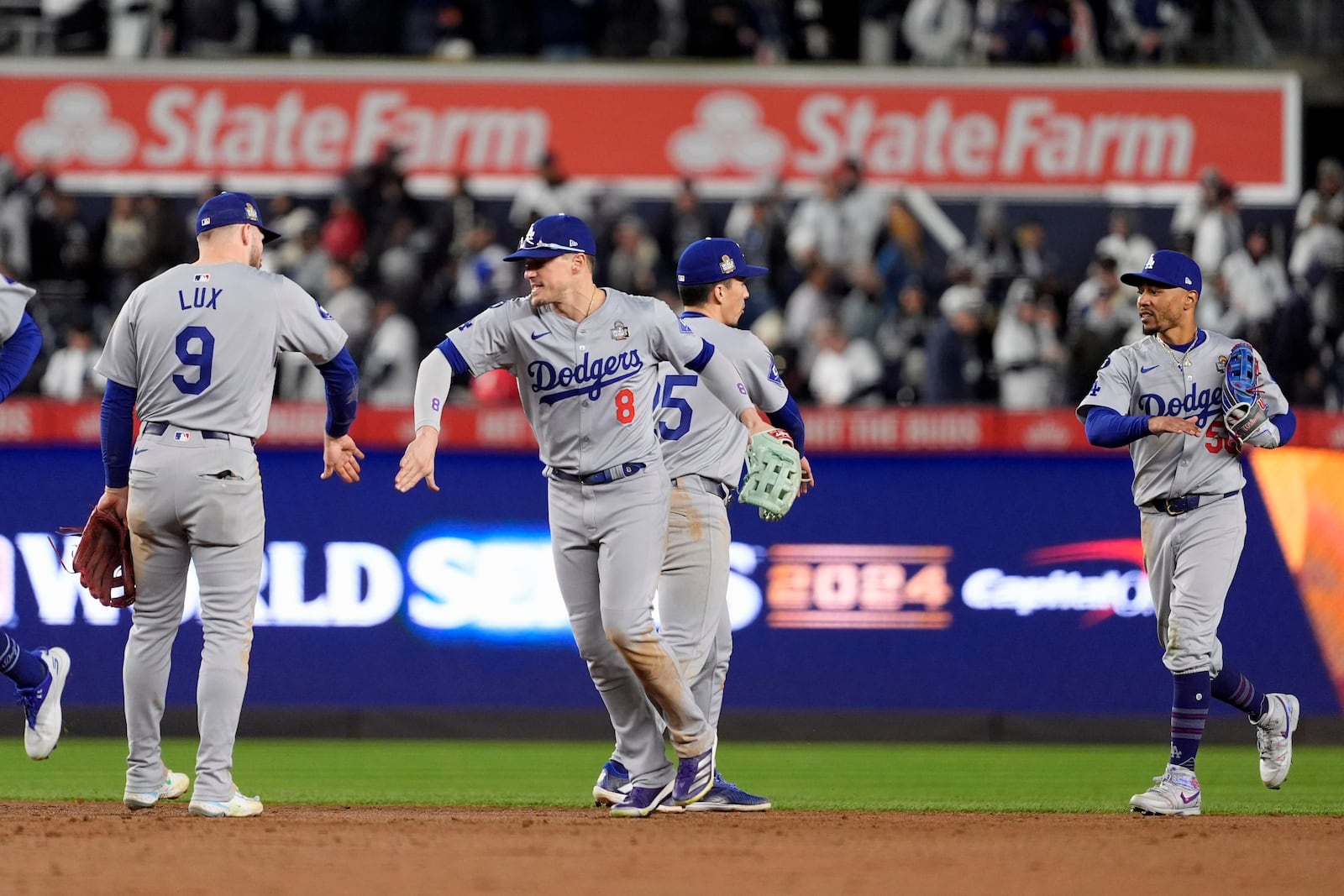 Los Angeles Dodgers' Gavin Lux (9), Kiké Hernández (8), Tommy Edman (25) and Mookie Betts (50) celebrate after Game 3 of the baseball World Series against the New York Yankees, Monday, Oct. 28, 2024, in New York. The Dodgers won 4-2. (AP Photo/Godofredo A. Vásquez)