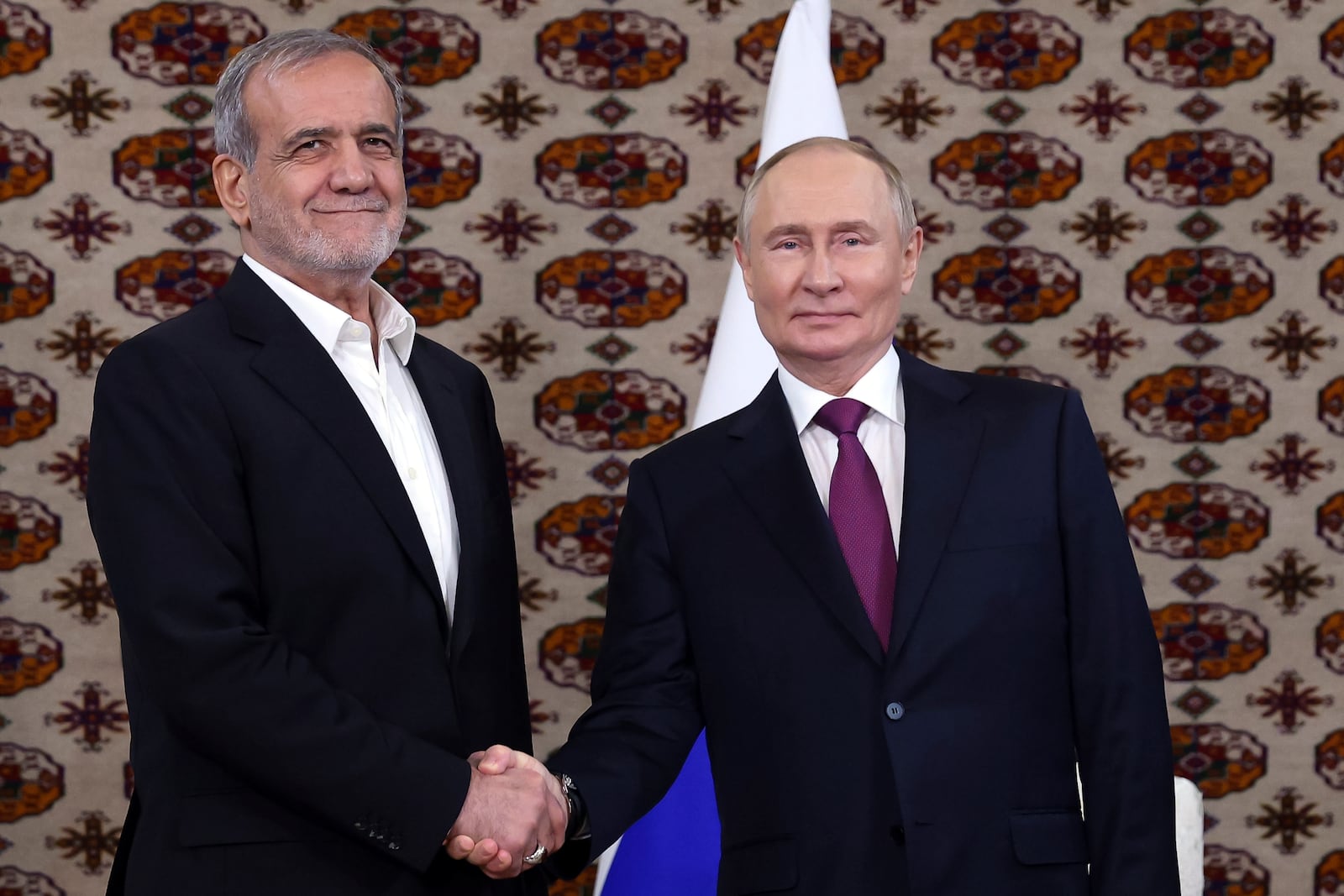 Russian President Vladimir Putin, right, and Iranian President Masoud Pezeshkian pose for a photo during their meeting on the sidelines of the International Forum "The Interconnection of Times and Civilizations – the basis of peace and development" dedicated to the 300th anniversary of the birth of the outstanding Turkmen poet and thinker Magtymguly Fragi in Ashgabat, Turkmenistan, Friday, Oct. 11, 2024. (Alexander Shcherbak, Sputnik, Kremlin Pool Photo via AP)