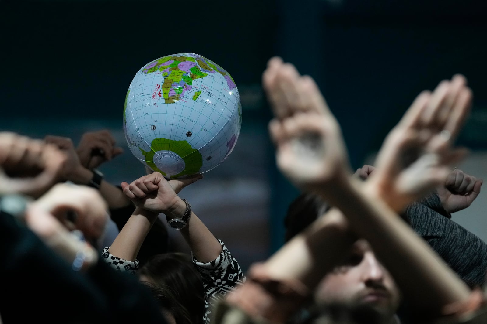 Activists hold an inflatable globe as they demonstrate in silence protesting a draft of a proposed deal for curbing climate change at the COP29 U.N. Climate Summit, Friday, Nov. 22, 2024, in Baku, Azerbaijan. (AP Photo/Rafiq Maqbool)