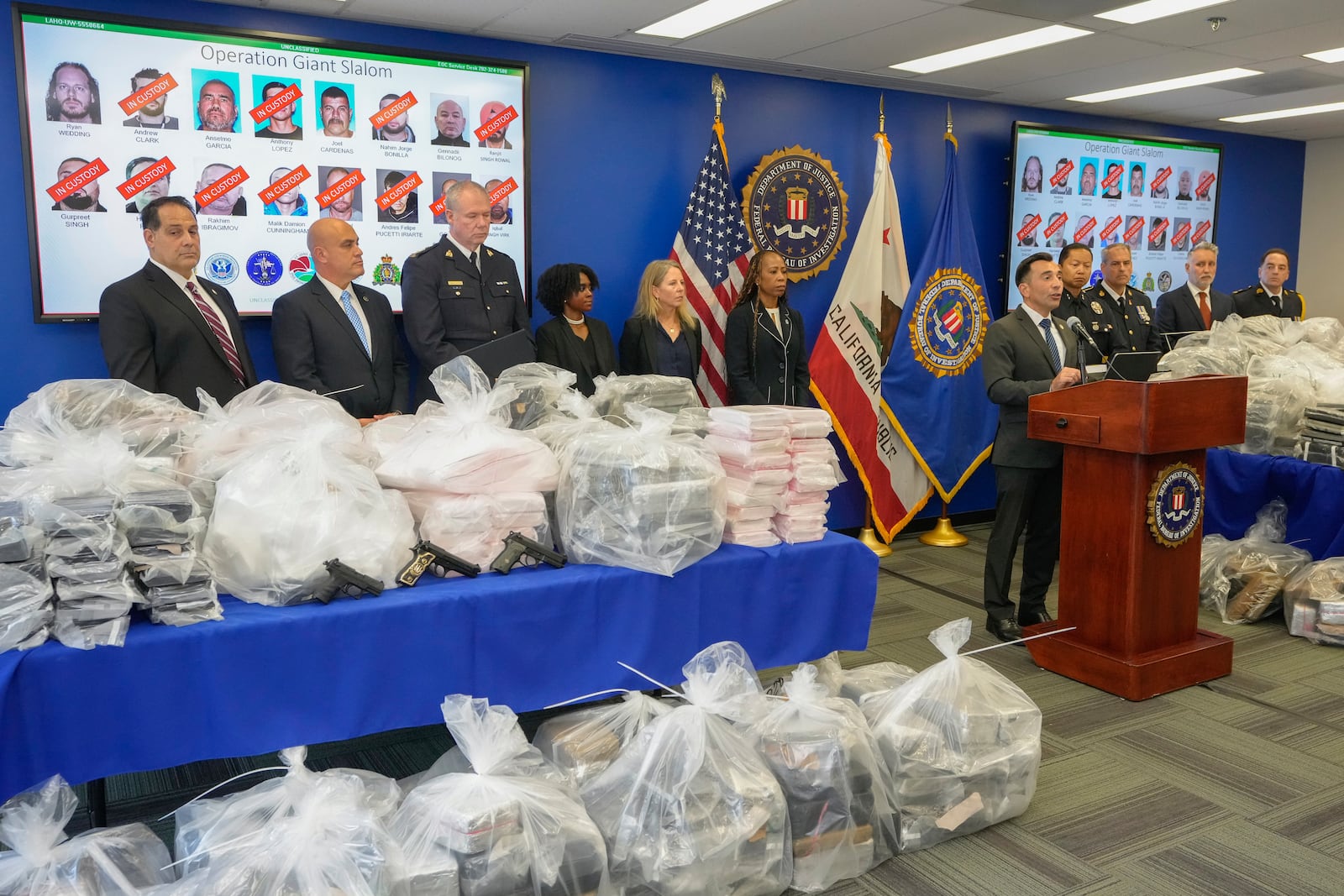 United States Attorney Martin Estrada, right at podium, joined by federal, local, and international officials, announces federal charges and arrests of alleged members of a transnational drug trafficking operation that routinely shipped hundreds of kilograms of cocaine from Colombia, through Mexico and Southern California, to Canada and other locations in the United States, during a news conference at the FBI offices in Los Angeles, Thursday, Oct. 17, 2024. (AP Photo/Damian Dovarganes)