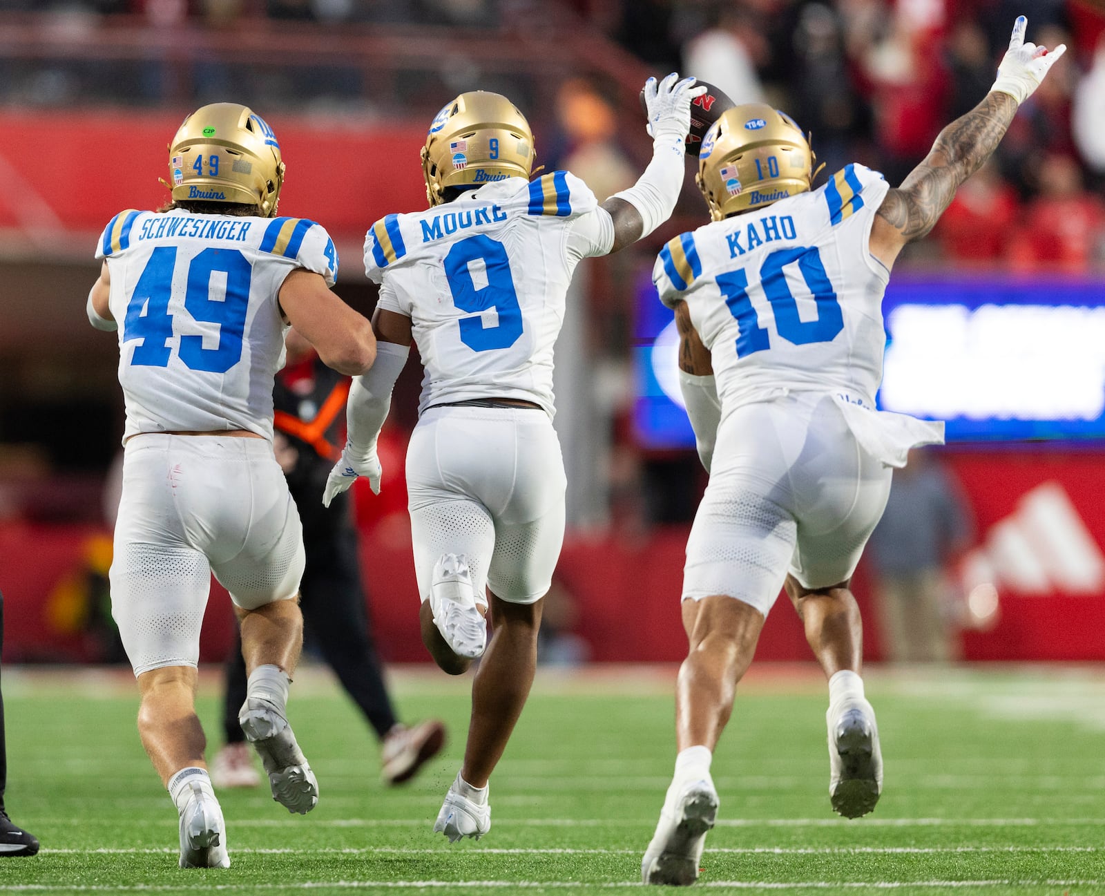 UCLA's Carson Schwesinger (49), Kaylin Moore (9) and Ale Kaho (10) celebrate Moore's interception to end the game against Nebraska in the second half of an NCAA college football game Saturday, Nov. 2, 2024, in Lincoln, Neb. UCLA defeated Nebraska 27-20. (AP Photo/Rebecca S. Gratz)