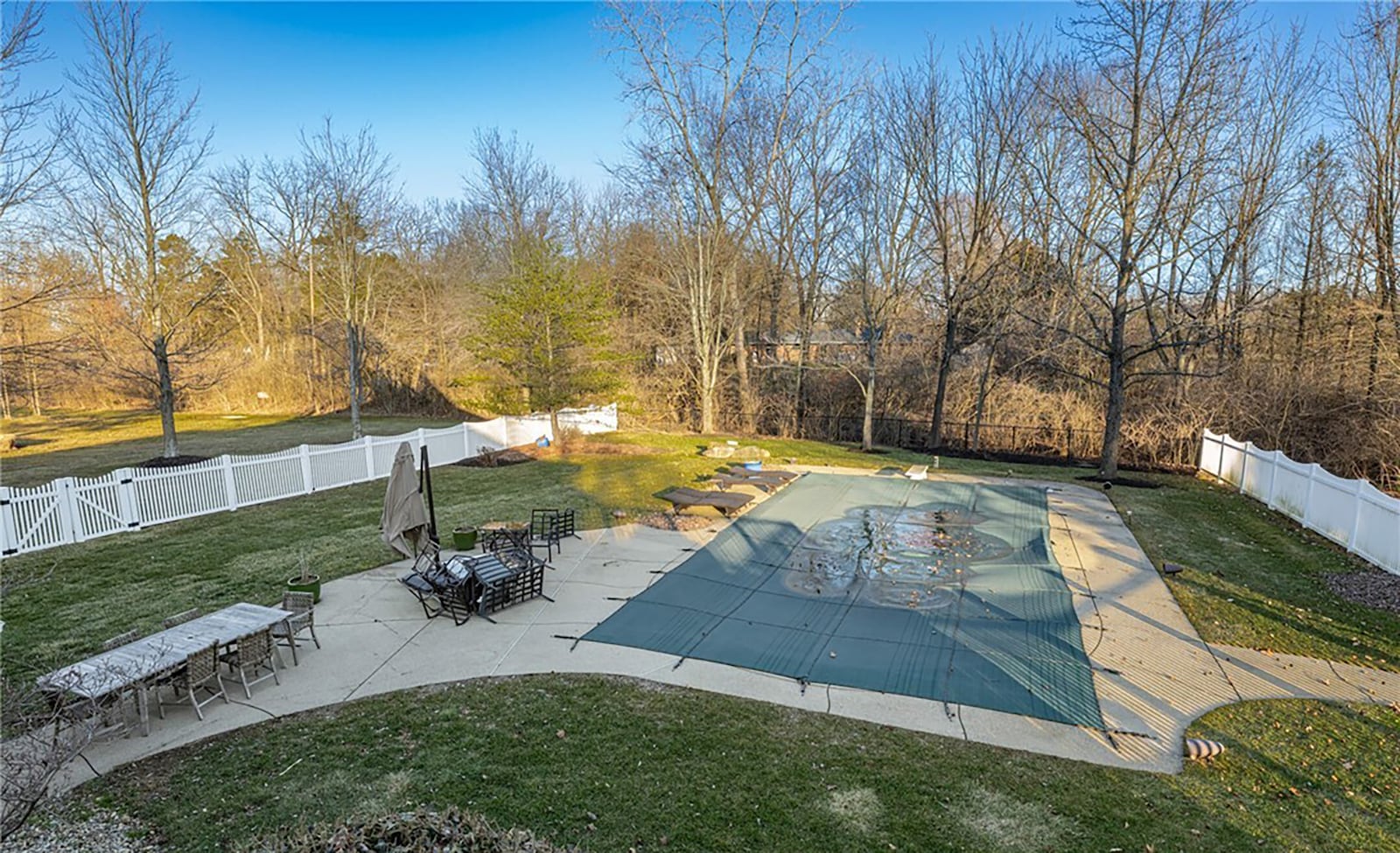 The inground pool is fully fenced and has an extended concrete deck surrounding it.