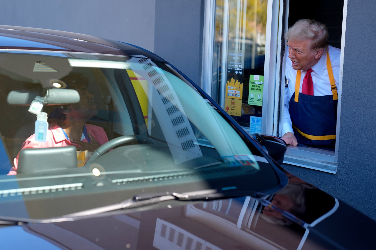 Republican presidential nominee former President Donald Trump speaks to a customer at a drive-thru window during a campaign stop at a McDonald's, Sunday, Oct. 20, 2024, in Feasterville-Trevose, Pa. (AP Photo/Evan Vucci)