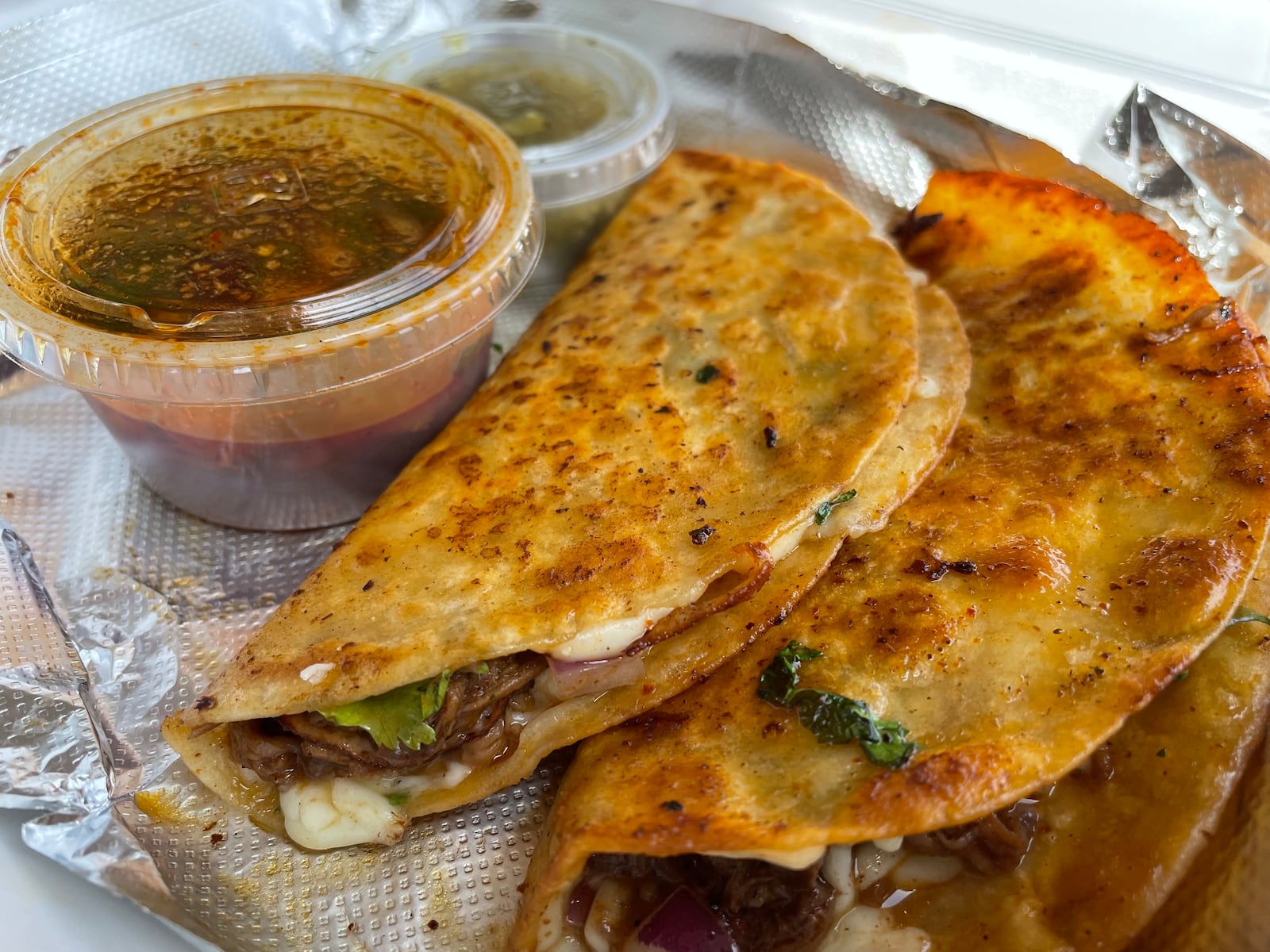 More Than A Apron in Miamisburg features Birria tacos made with beef, chicken or lamb, as well as Birria bowls, fries and mac and cheese. NATALIE JONES/STAFF