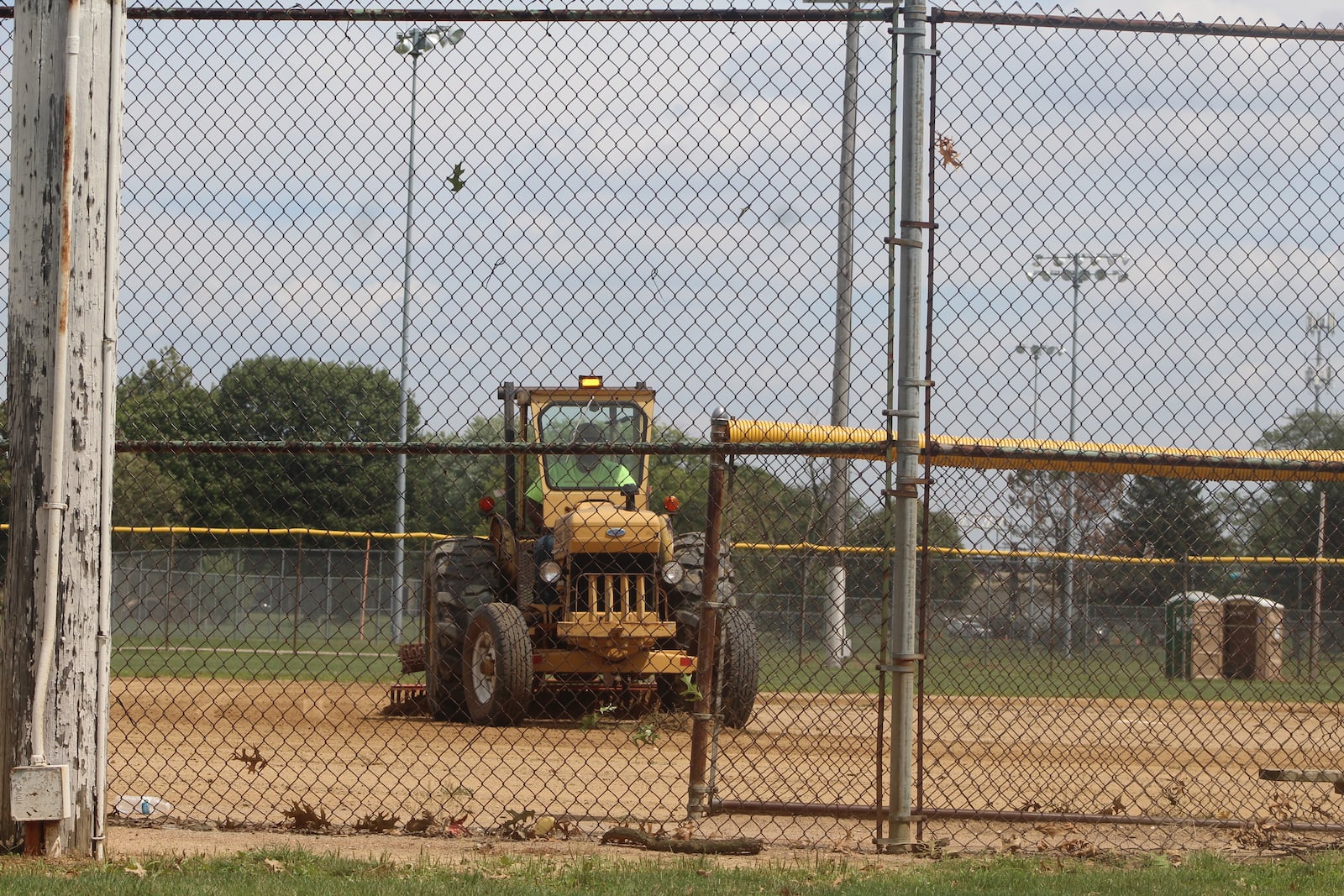 A maintenance worker uses equipment to work on the infield of a softball field at Kettering Field in Dayton on Thursday, Aug. 17, 2023. CORNELIUS FROLIK / STAFF