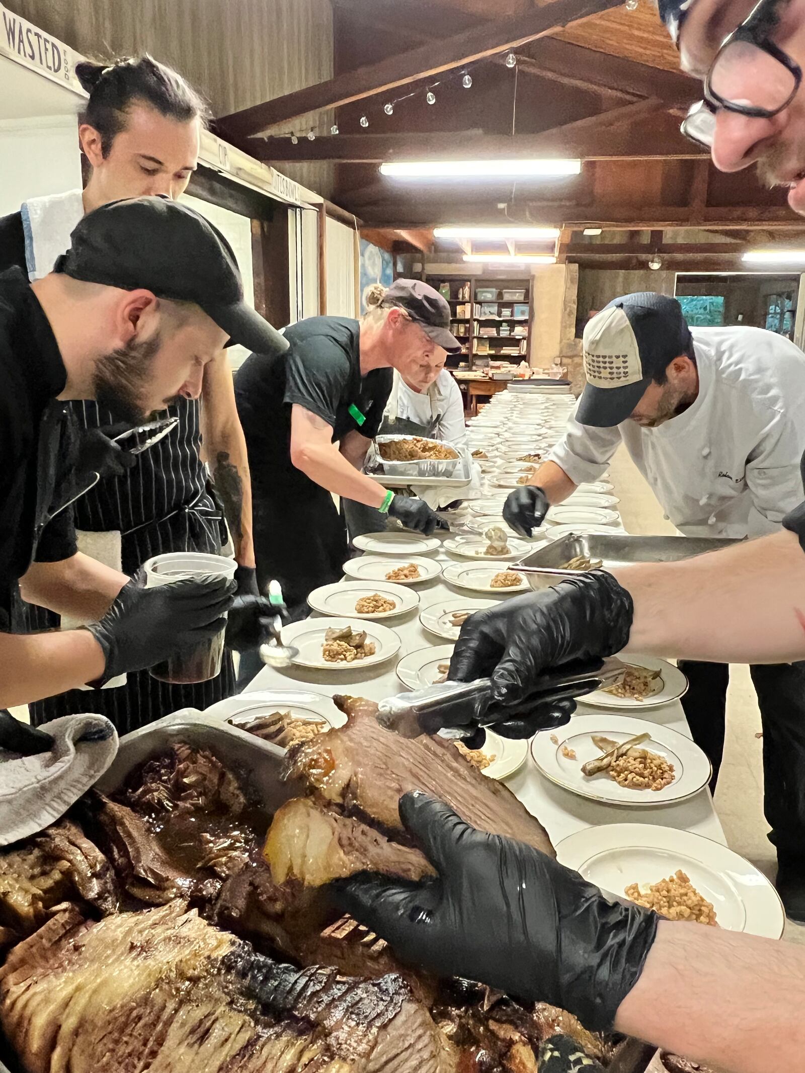 Local chefs plate slow-braised his beef brisket at the Whoo Cooks For You 2023 benefit. ALEXIS LARSEN/CONTRIBUTOR