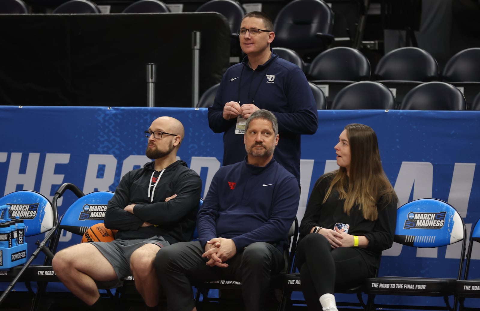 Dayton strength coach Casey Cathrall and trainers Mike Mulcahey and Shelby Davis and Athletic Director Neil Sullivan, back, talk as the team practices for the NCAA tournament at the Delta Center in Salt Lake City, Utah, on Wednesday, March 20, 2024. David Jablonski/Staff