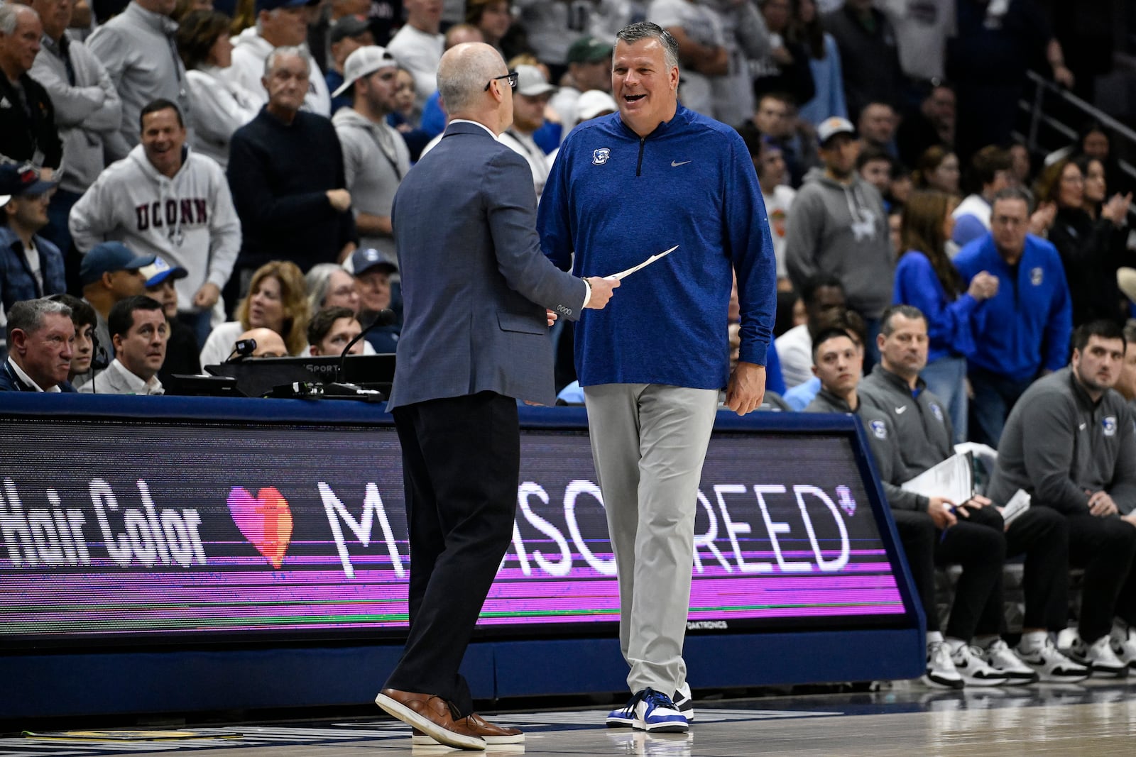 Creighton head coach Greg McDermott, right, walks over to talk to UConn head coach Dan Hurley as his team shoots a free throw in the second half of an NCAA college basketball game, Saturday, Jan. 18, 2025, in Storrs, Conn. (AP Photo/Jessica Hill)