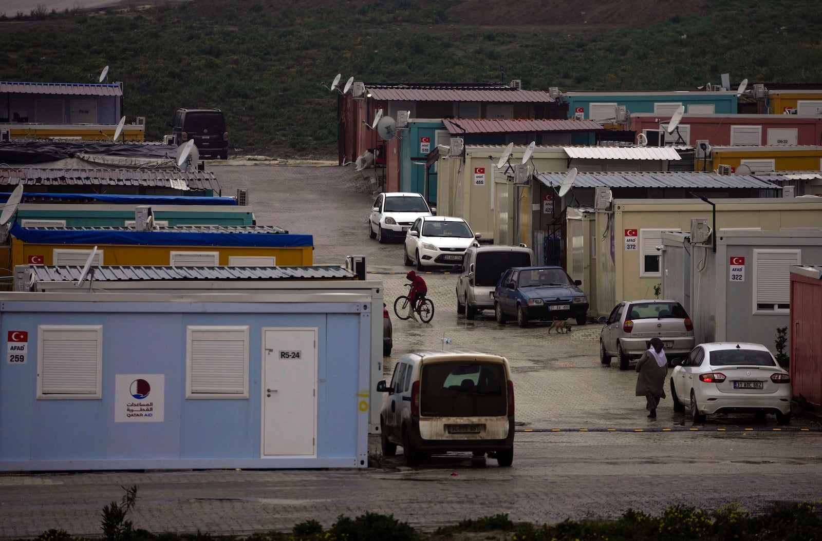 FILE - A boy rides his bicycle among containers homes sheltering survivors of the powerful Feb. 6, 2023 earthquake, in Antakya, southern Turkey, Friday, Jan. 12, 2024. (AP Photo/Khalil Hamra, File)