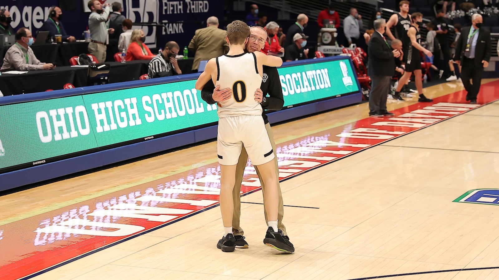 Centerville boys basketball coach Brook Cupps embraces his son, Gabe, the team's sophomore point guard, after the Elks beat Westerville Central in the D-I state championship game Sunday night at UD Arena. Michael Cooper/CONTRIBUTED