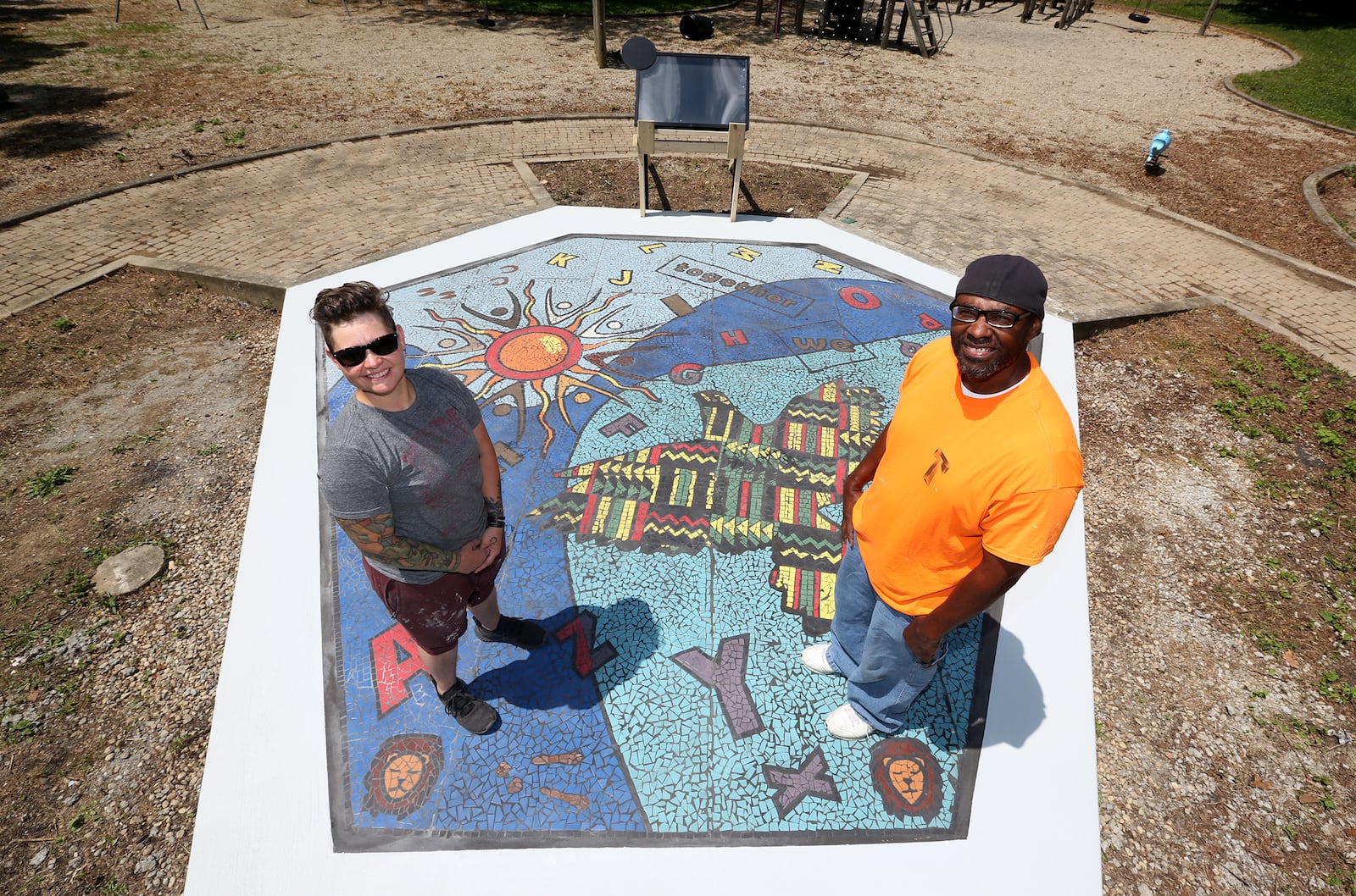 "Together We Rise," designed by Jes McMillan, founder of the Mosaic Institute of Dayton and Charles Boogie Sweeney, a Dayton artist, is a new large-scale play area and work of art in West Dayton. The in-ground mosaic is a play station designed with interactive games, alphabet letters and raised areas for crayon rubbings. It is located in a playground at the intersection of Harvard Boulevard and Burroughs Drive on the Omega CDC Harvard Campus.  LISA POWELL / STAFF