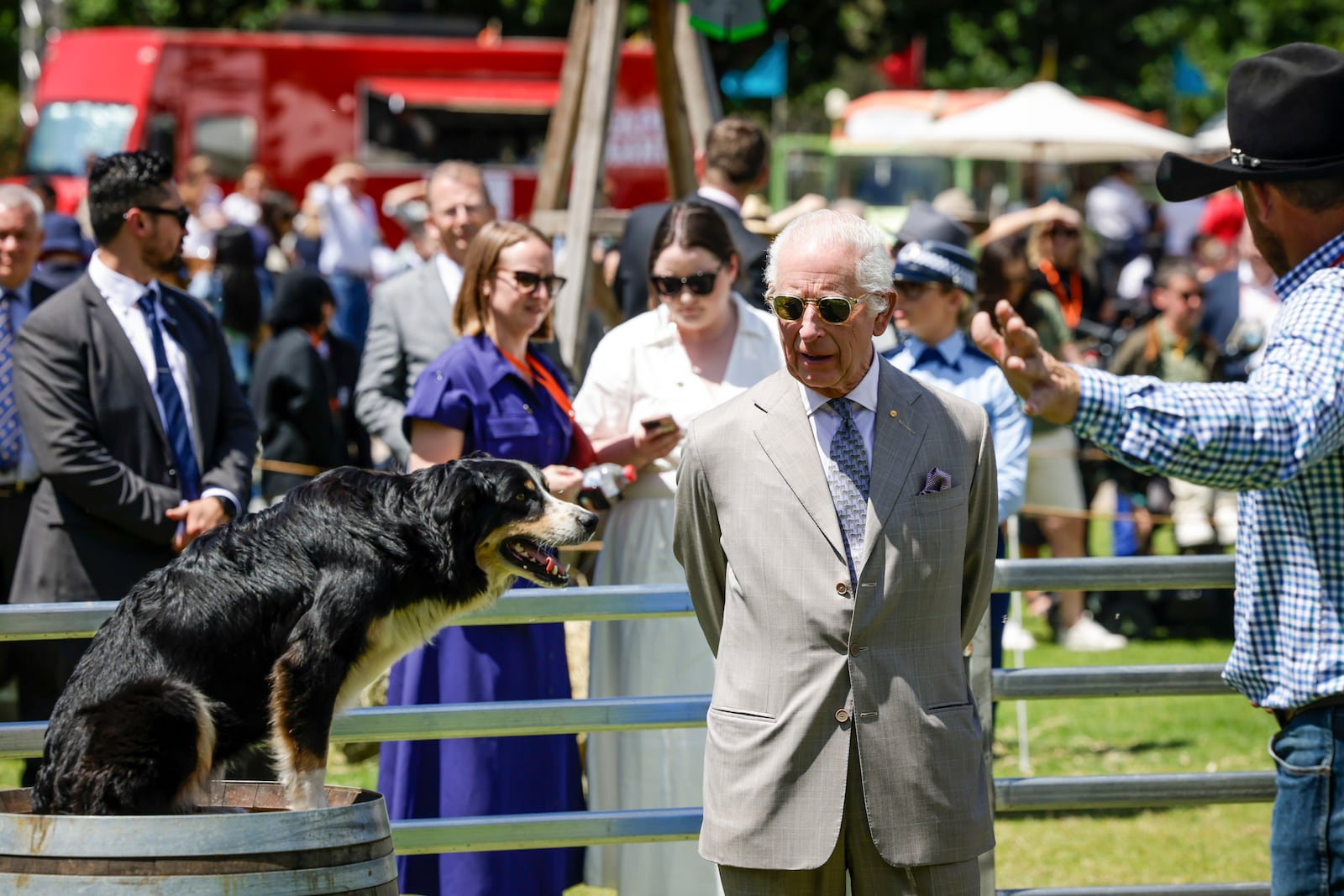 Britain's King Charles III, center, views a sheep dog as he attends the Premier's Community BBQ on Tuesday Oct. 22, 2024 in Sydney, Australia. (Brook Mitchell/Pool Photo via AP)