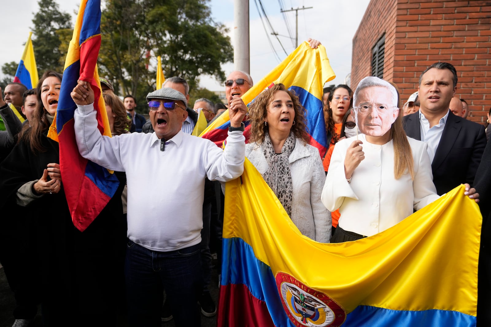 Supporters of Colombia's former President Alvaro Uribe gather outside the court where he is attending a hearing on charges of witness tampering and bribery in Bogota, Colombia, Monday, Feb. 10, 2025. (AP Photo/Fernando Vergara)