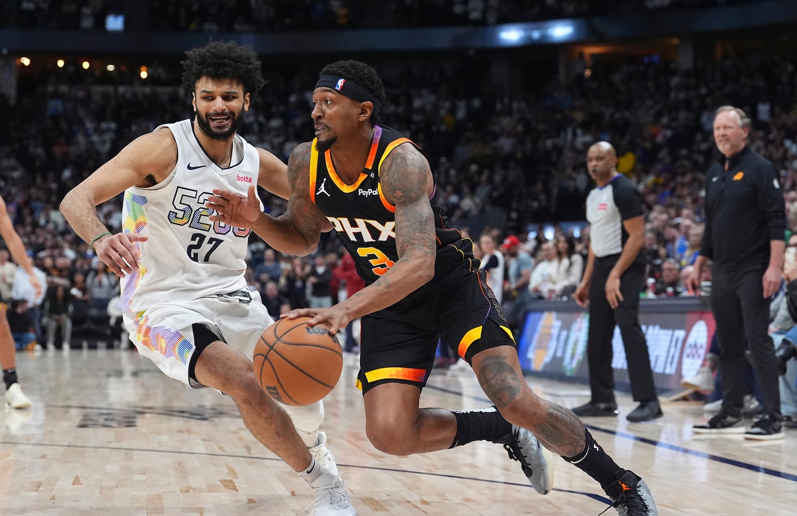 Phoenix Suns guard Bradley Beal, right, drives past Denver Nuggets guard Jamal Murray in overtime of an NBA basketball game Friday, March 7, 2025, in Denver. (AP Photo/David Zalubowski)