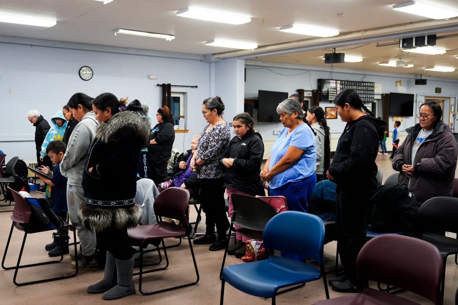 Community members bow their heads for a prayer during a "singspiration" community event at the village community center in Kaktovik, Alaska, Monday, Oct. 14, 2024. (AP Photo/Lindsey Wasson)