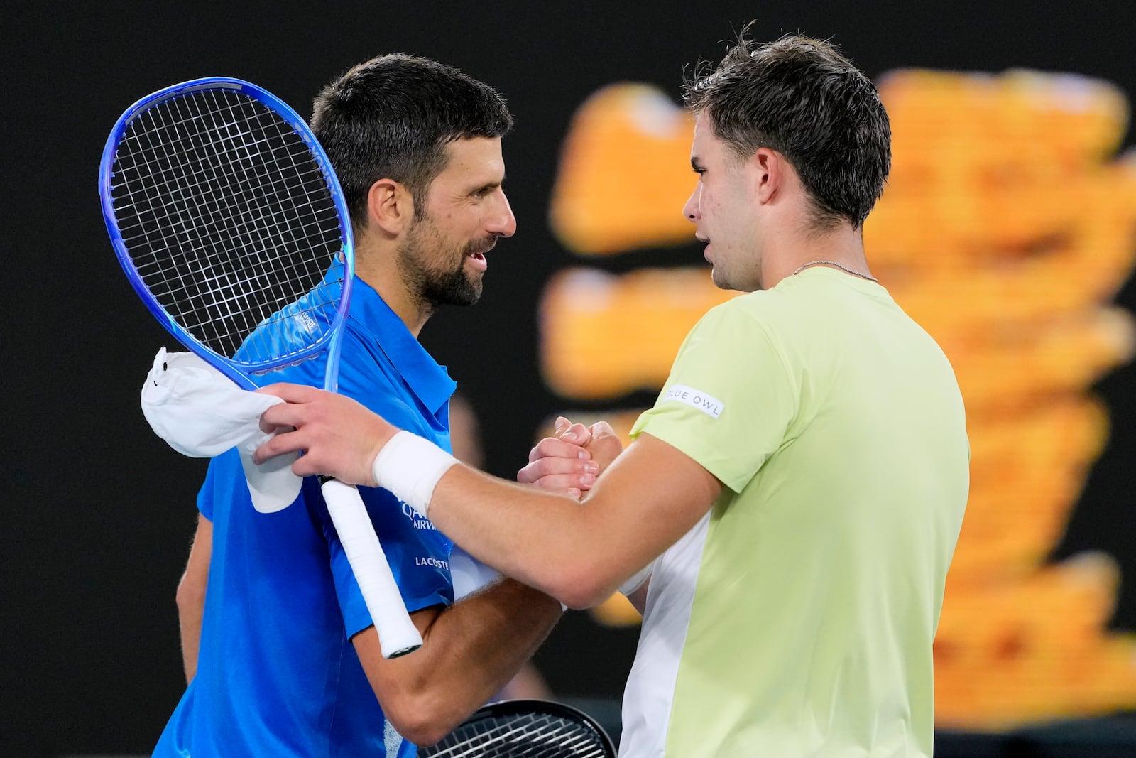 Novak Djokovic, left, of Serbia is congratulated by Jaime Faria of Portugal following their second round match at the Australian Open tennis championship in Melbourne, Australia, Wednesday, Jan. 15, 2025. (AP Photo/Vincent Thian)