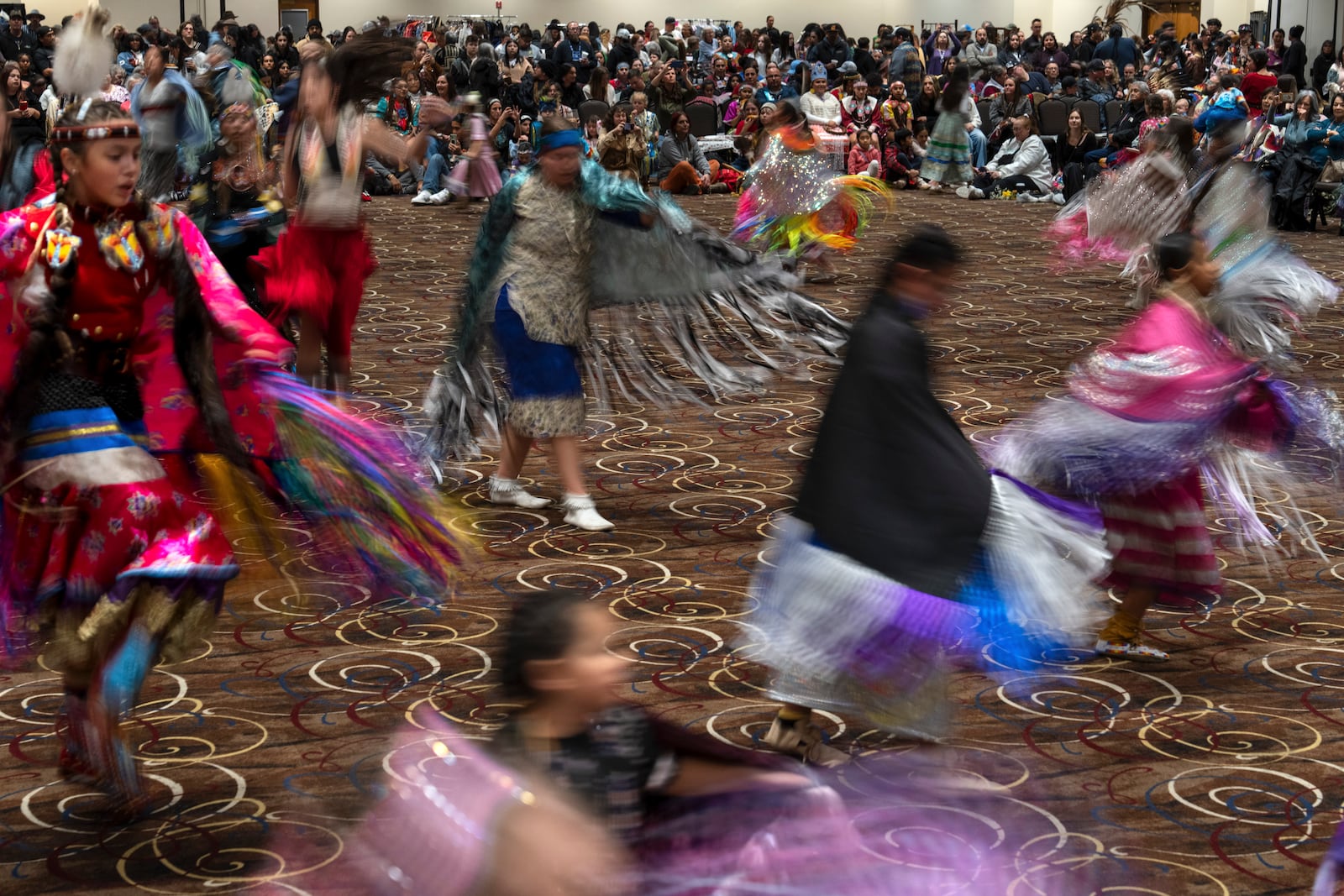 People dance in a powwow at Chinook Winds Casino Resort, Saturday, Nov. 16, 2024, in Lincoln City, Ore. (AP Photo/Jenny Kane)