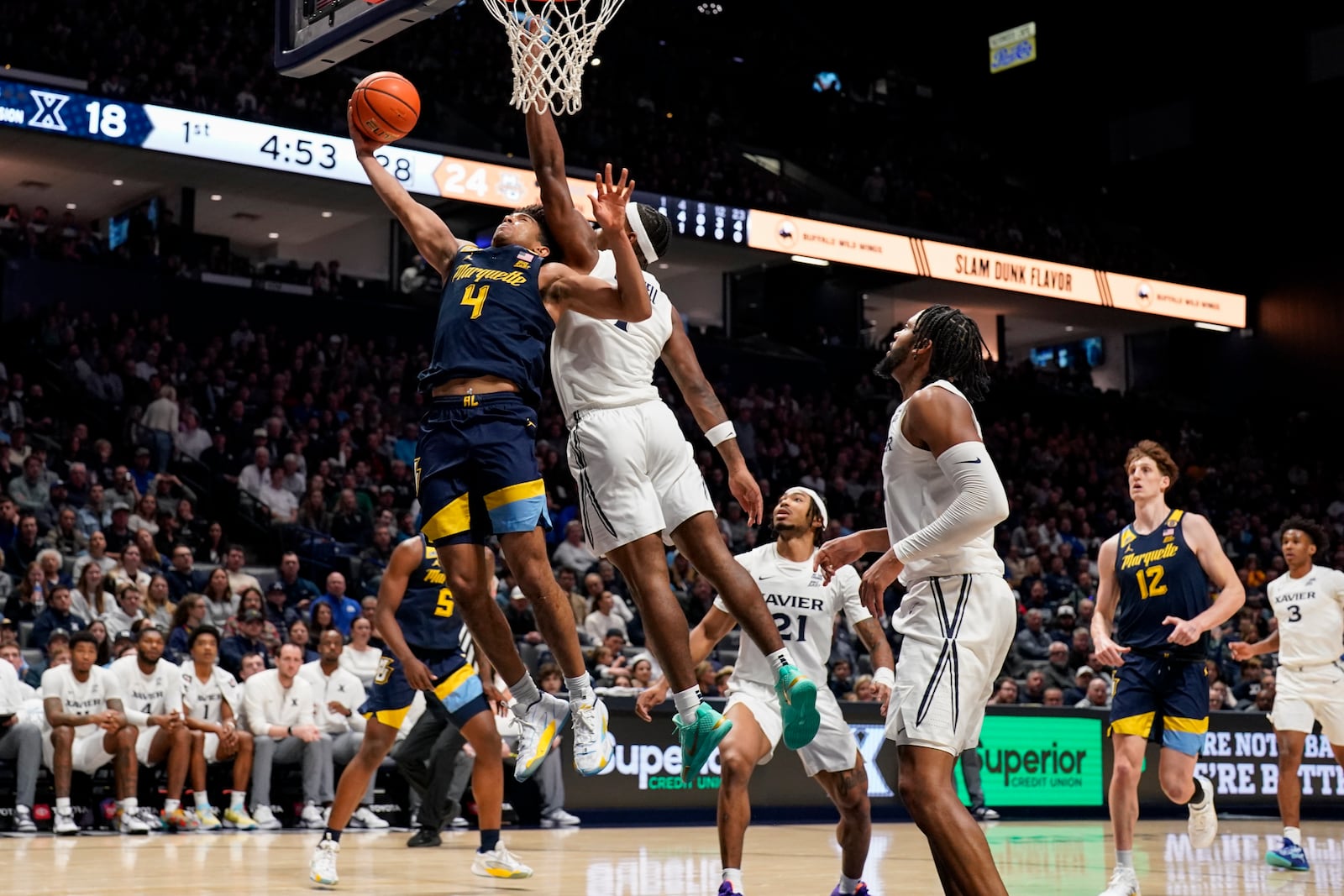 Marquette guard Stevie Mitchell (4) shoots against Xavier guard Marcus Foster (1) during the first half of an NCAA college basketball game, Saturday, Dec. 21, 2024, in Cincinnati. (AP Photo/Jeff Dean)