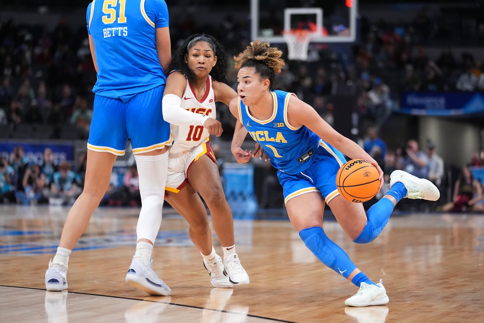 UCLA guard Kiki Rice (1) drives the ball as Southern California guard Malia Samuels (10) works around a screen by Lauren Betts (51) during the second half of an NCAA college basketball game in the championship of the Big Ten Conference tournament in Indianapolis, Sunday, March 9, 2025. (AP Photo/Michael Conroy)