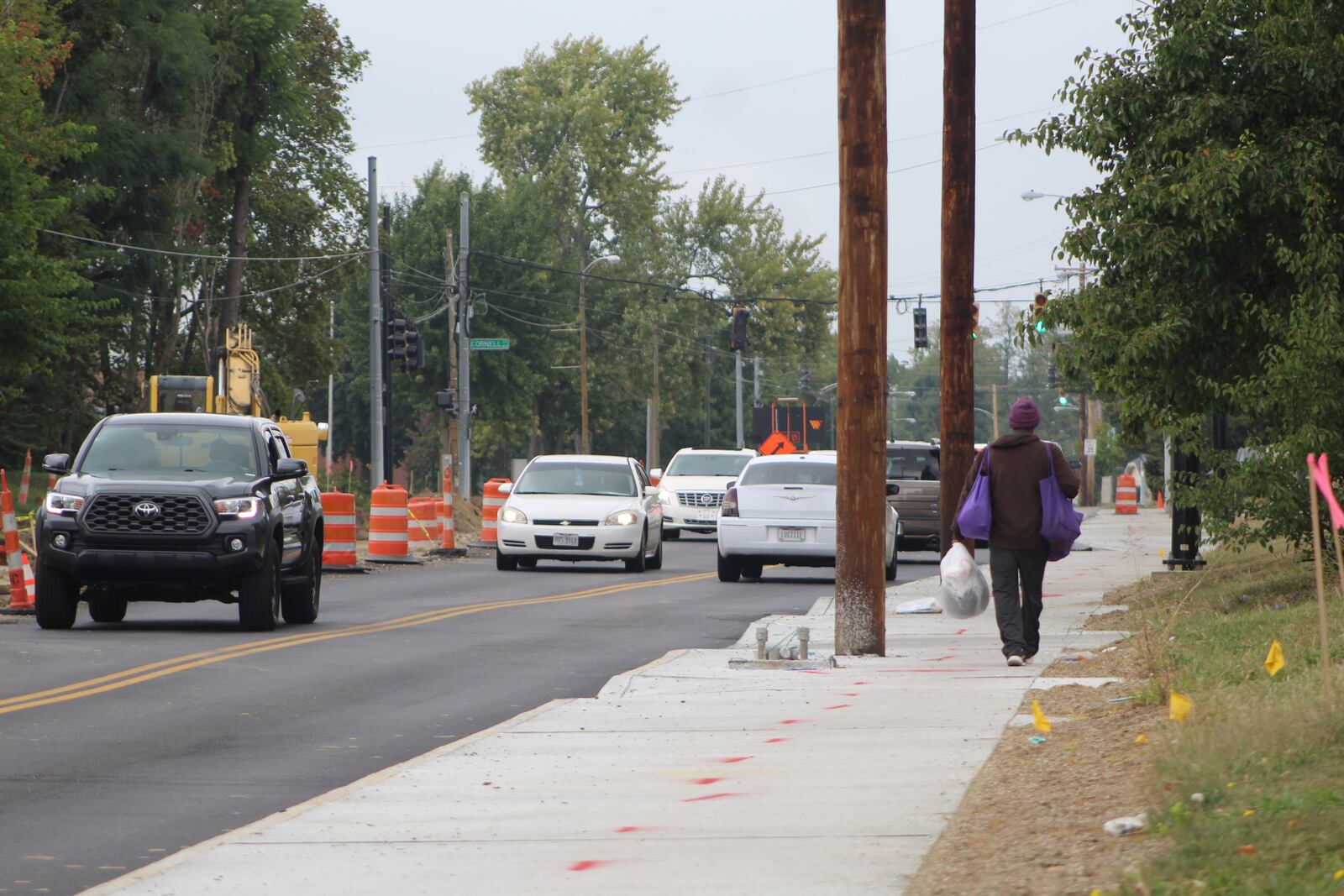 A pedestrian walks along Salem Avenue in Dayton by a construction zone. CORNELIUS FROLIK / STAFF