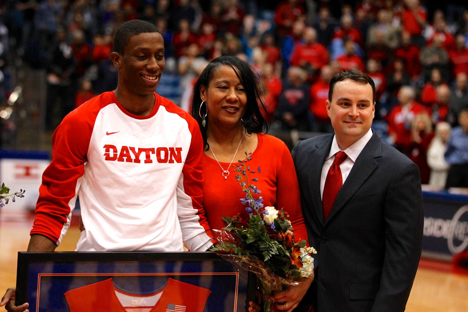 Jordan Sibert, left, and his mom Sheila stand with Dayton coach Archie Miller on Senior Night on Tuesday, March 3, 2015, at UD Arena. David Jablonski/Staff