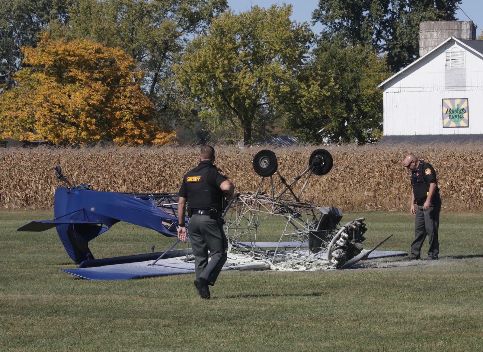 Clark County Sheriff’s deputies look over the remains of an airplane that crashed and burst into flames on the runway Tuesday, Oct. 13, 2020, at the Andy Barnhart Memorial Airport in New Carlisle. BILL LACKEY/STAFF