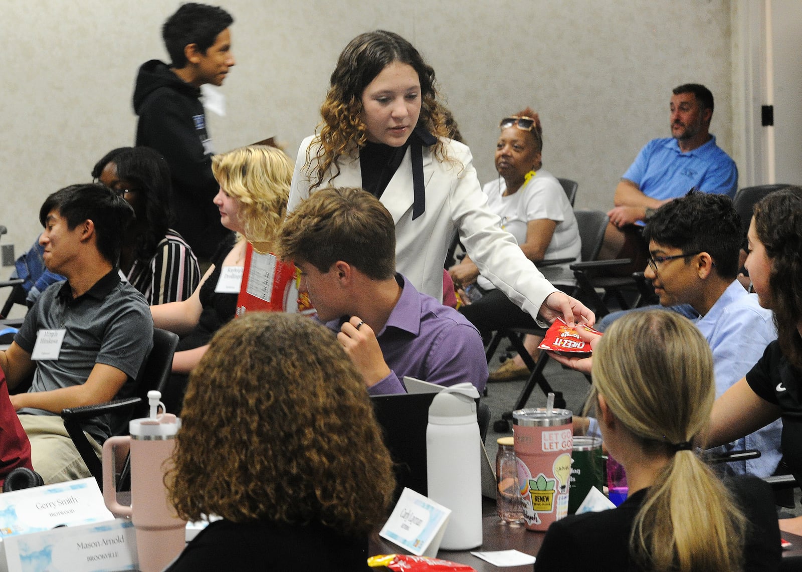 Oakwood student Charlotte Spaulding hands out packages of Cheez-It baked snack crackers to the audience Wednesday, June 12, 2024. The Cheez-It was first made in Dayton in 1921. This was part of a project presentation about why Dayton is the place to be for young professionals. Marshall Gorby / Staff