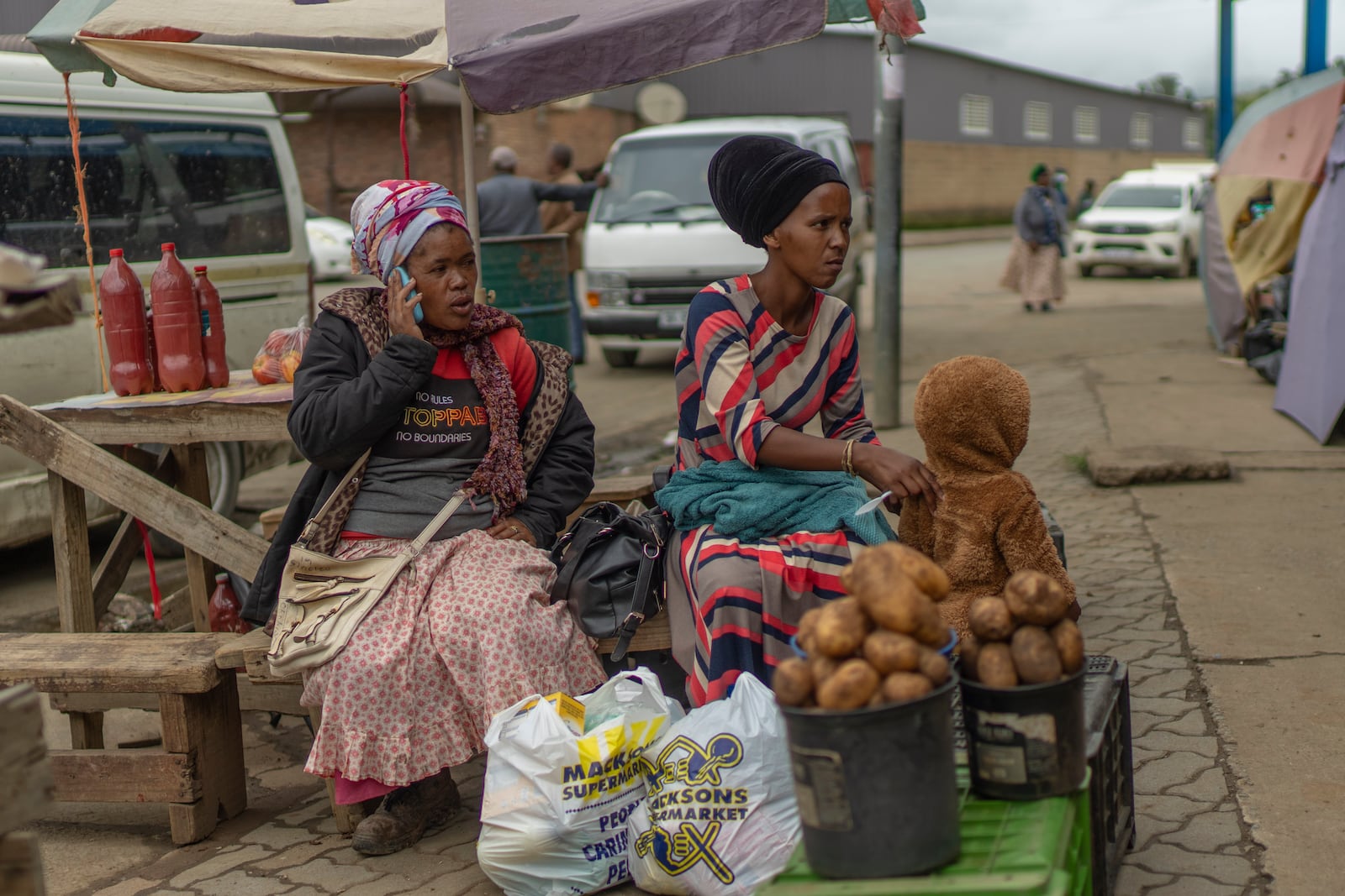 Women sell goods at the market in Umzimkhulu , South Africa, Wednesday, Nov. 12, 2025, in an area where one of millions of patients in South Africa affected by U.S. President Donald Trump's global foreign aid freeze, raising worry about HIV patients defaulting on treatment. (AP Photo/Jerome Delay}