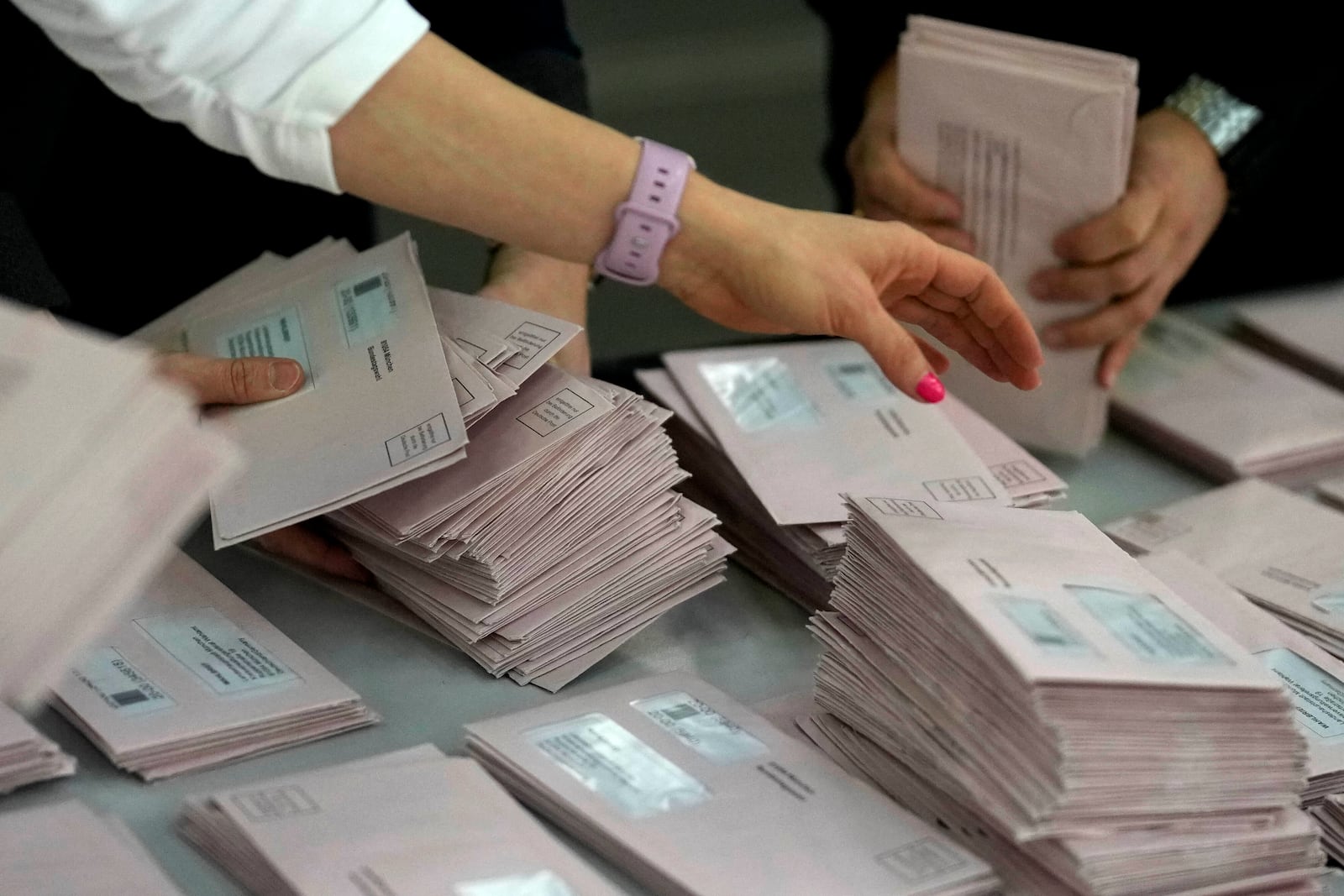 Volunteers prepare postal votes during the German national election in Munich, Germany, Sunday, Feb. 23, 2025. (AP Photo/Matthias Schrader)