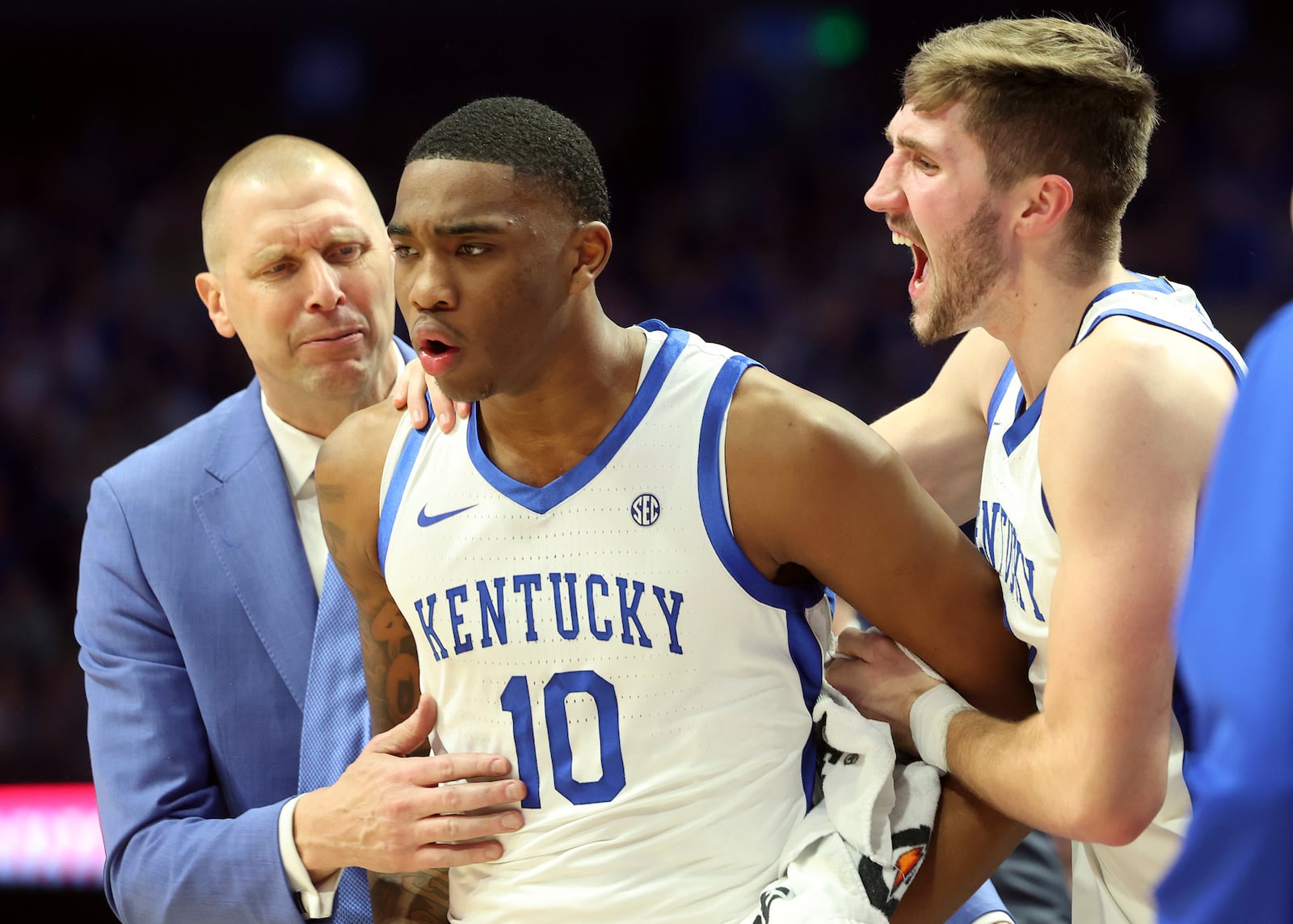 Kentucky's Brandon Garrison (10) is congratulated by head coach Mark Pope, left, and Andrew Carr, right, after making a play during the second half of an NCAA college basketball game against Louisville in Lexington, Ky., Saturday, Dec. 14, 2024. (AP Photo/James Crisp)