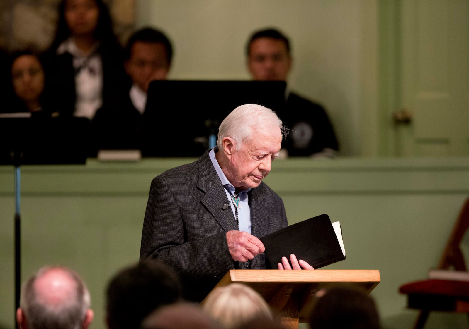 FILE - Former President Jimmy Carter opens up a Bible while teaching Sunday school class at Maranatha Baptist Church in his hometown, Aug. 23, 2015, in Plains, Ga. (AP Photo/David Goldman, File)