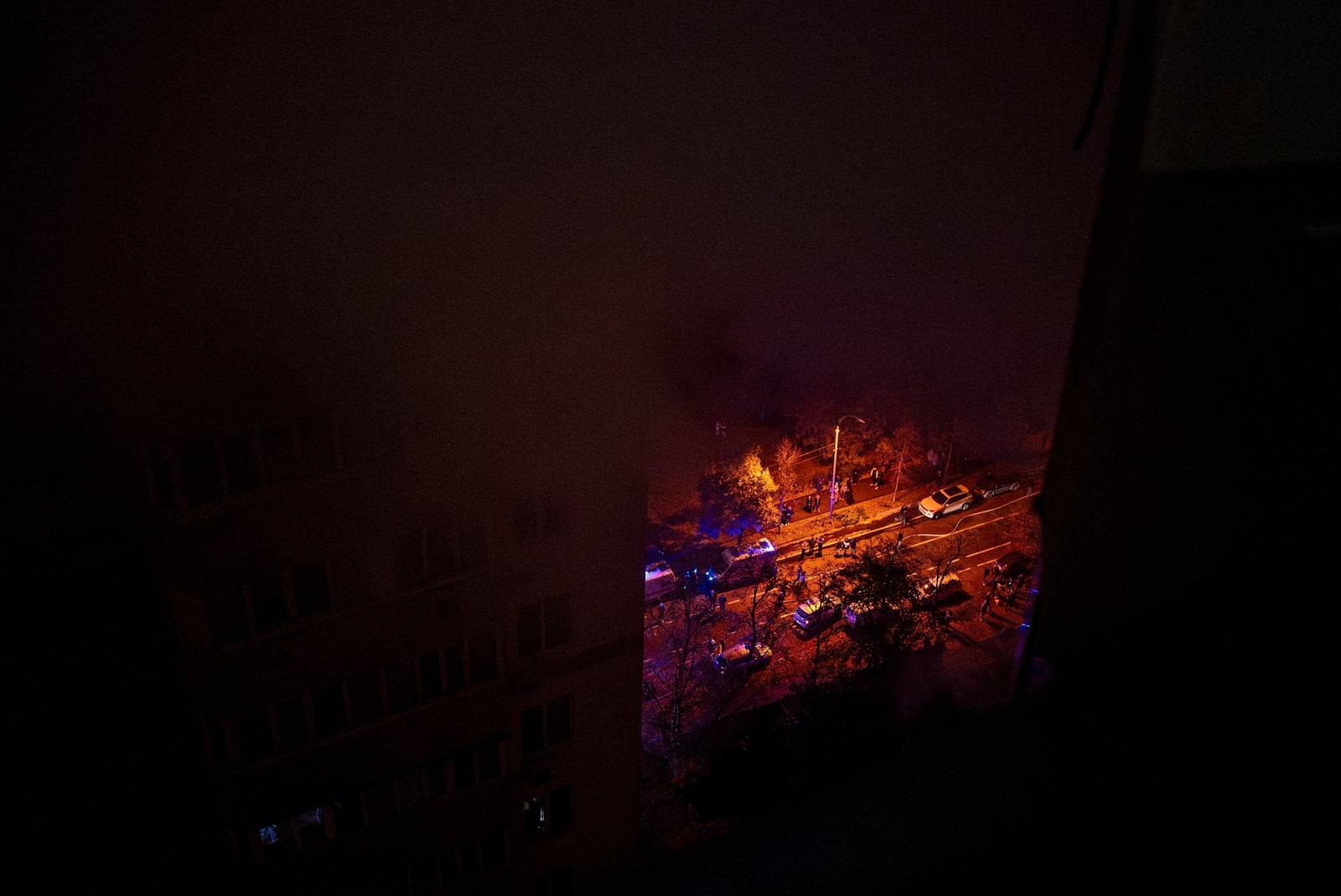 Emergency service vehicles are seen through the smoke from a fire caused by the attack of Russian drones that killed a teenager in Kyiv, Ukraine, Friday, Oct. 25, 2024. (AP Photo/Alex Babenko)