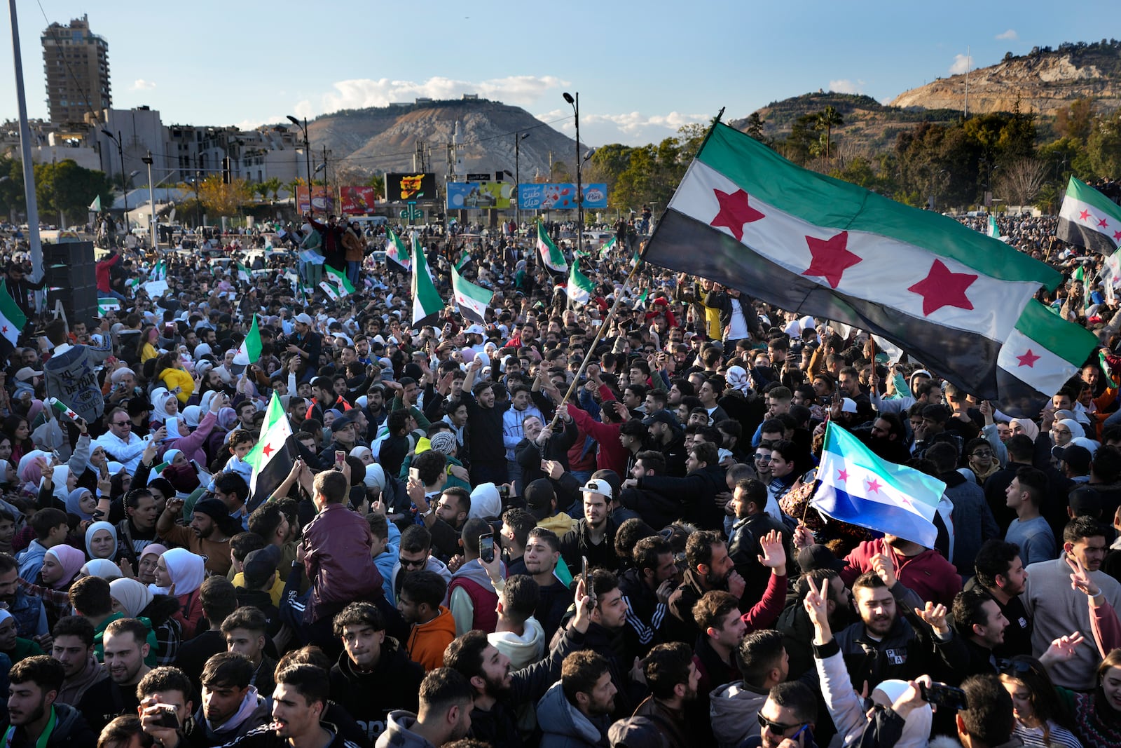 Syrians celebrate during a demonstration following the first Friday prayers since Bashar Assad's ouster, in Damascus' central square, Syria, on Friday, Dec. 13, 2024. (AP Photo/Hussein Malla)