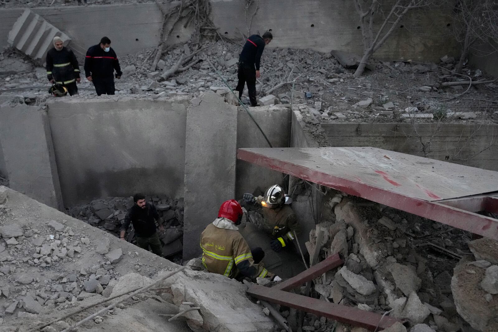 Rescue workers search for victims between the rubble of destroyed a house that was hit in an Israeli airstrike in Baalchmay village east of Beirut, Lebanon, Tuesday, Nov. 12, 2024. (AP Photo/Hassan Ammar)